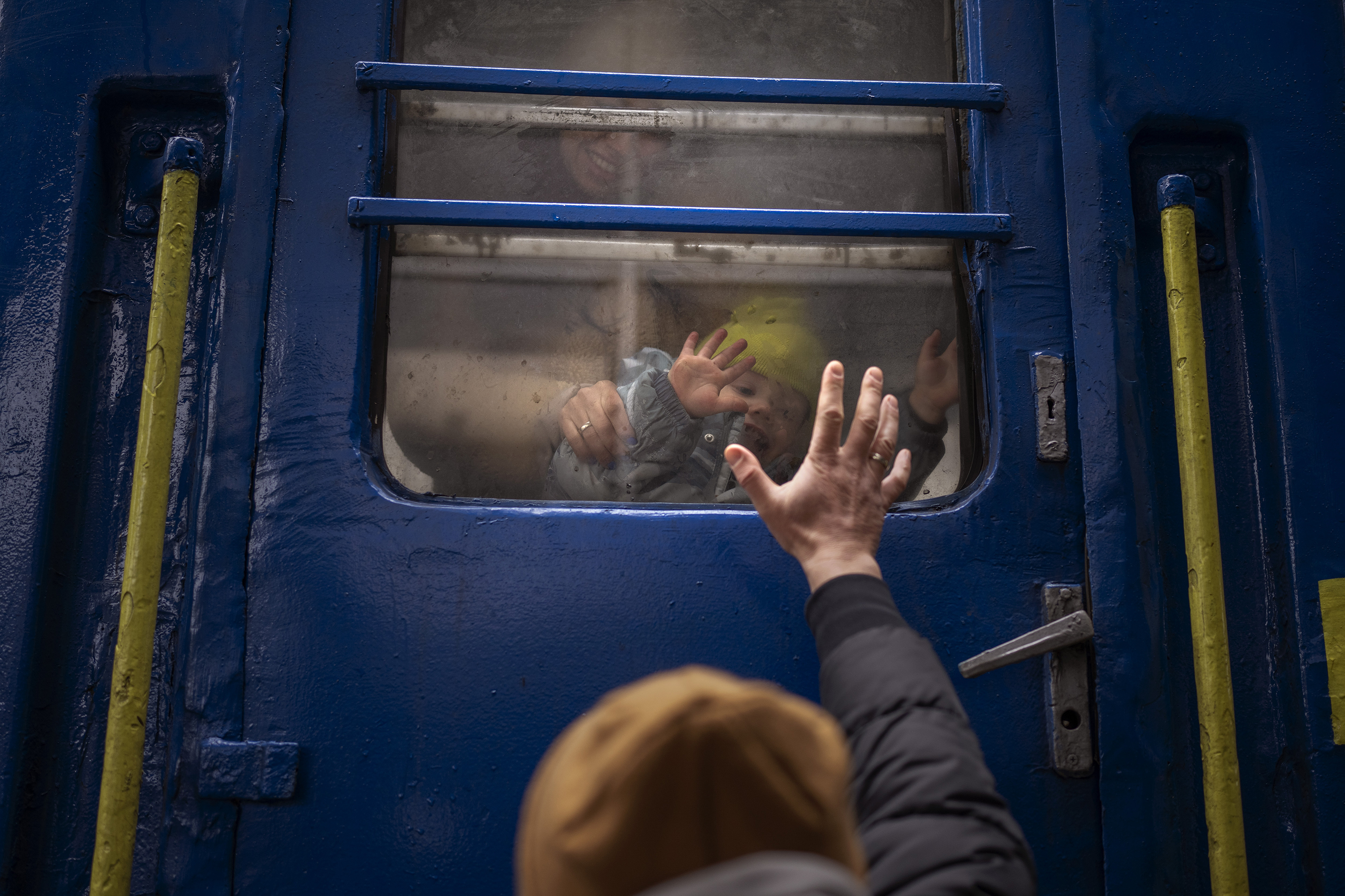 Stanislav, 40, says goodbye to his son, David, 2, and his wife, Anna, 35, on a train to Lviv, Ukraine, at Kyiv's train station Thursday, March 3. Stanislav was staying to fight while his family was leaving the country to seek refuge in a neighboring country.