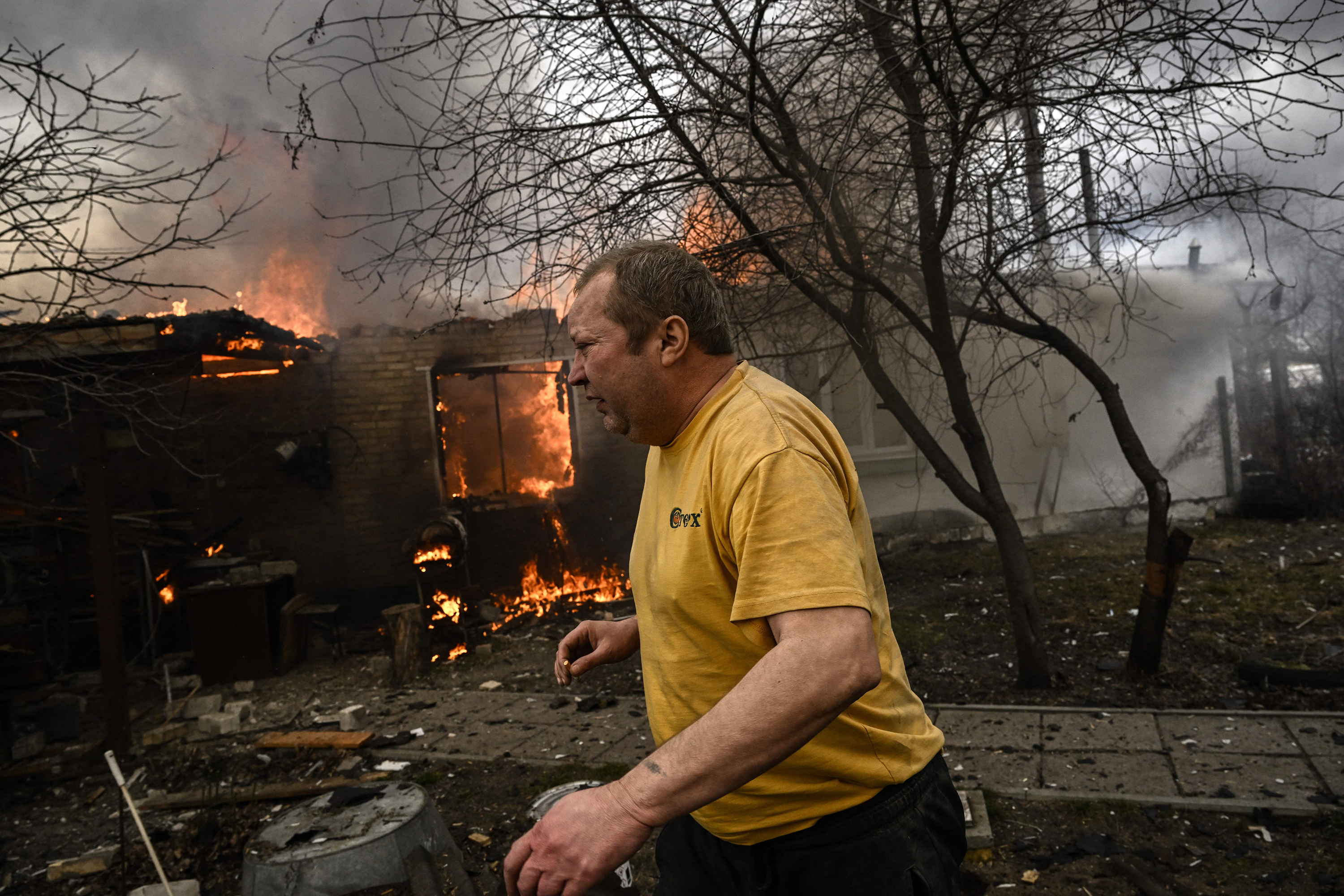 Yevghen Zbormyrsky, 49, runs in front of his burning home after it was shelled in the city of Irpin, Ukraine, outside the country's capital of Kyiv, on Friday, March 4. (AFP via Getty Images)