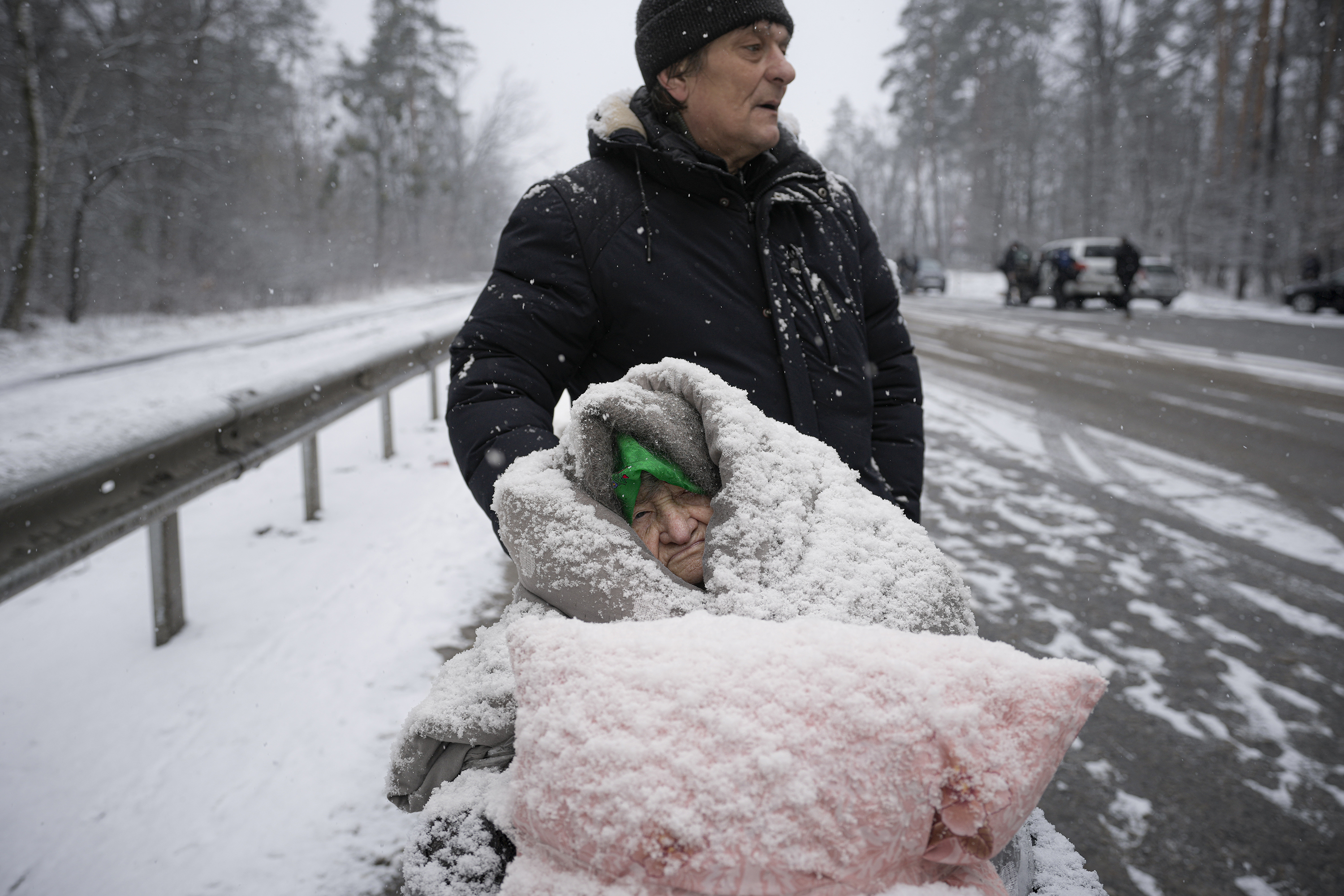 March 8: An elderly woman is coated in snow as she sits in a wheelchair after being evacuated from Irpin.