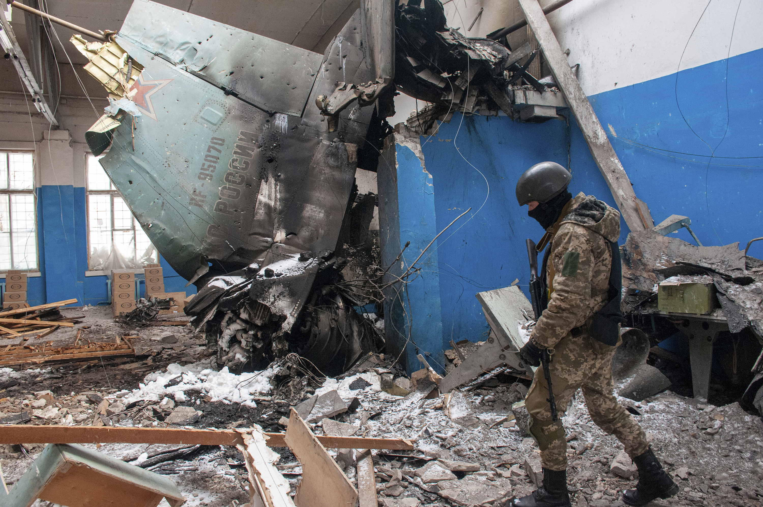 March 8: A Ukrainian serviceman walks past the vertical tail fin of a Russian Su-34 bomber standing in a damaged building in Kharkiv.