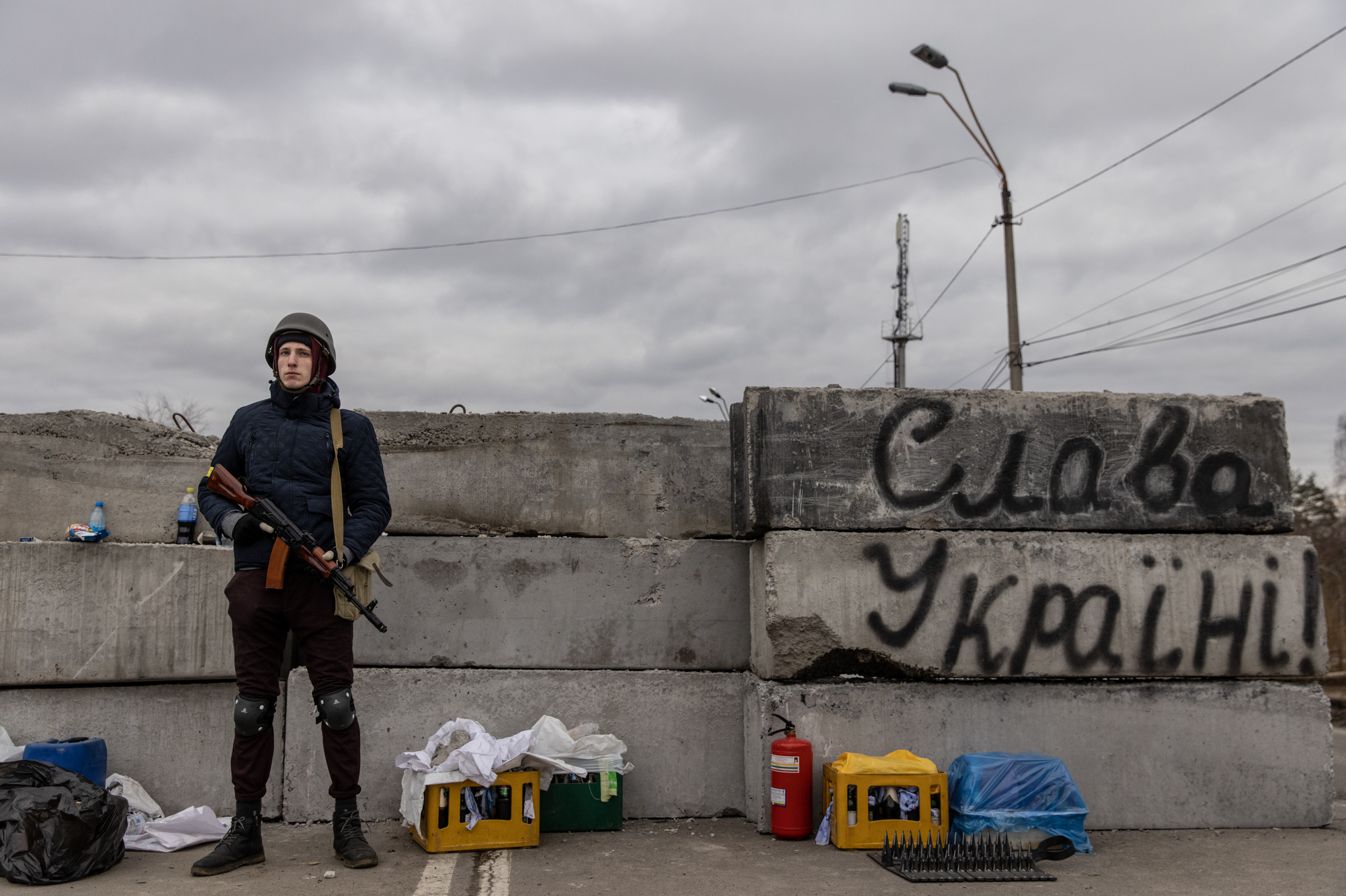 A member of a Territorial Defense unit guards a barricade next to writing saying &quot;Glory To Ukraine&quot; close to the eastern frontline on Saturday in Kyiv. Russia is continuing an assault on Ukraine's major cities. (Getty Images)