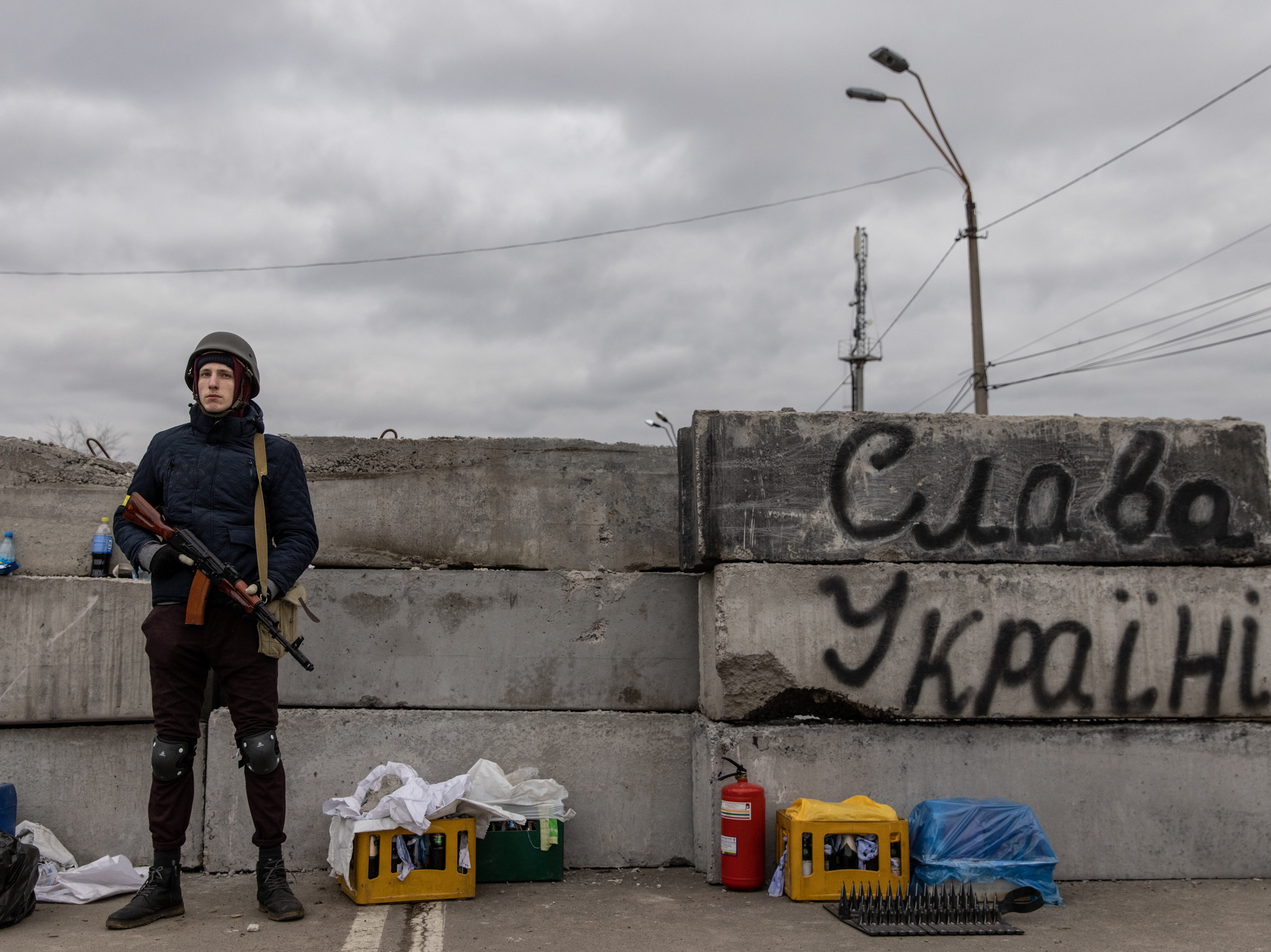 KYIV, UKRAINE - MARCH 05: A member of a Territorial Defence unit guards a barricade next to writing saying &quot; Glory To Ukraine&quot; close to the eastern frontline on March 05, 2022 in Kyiv, Ukraine. Russia continues assault on Ukraine's major cities, including the capital Kyiv, more than a week after launching a large-scale invasion of the country. (Photo by Chris McGrath/Getty Images)