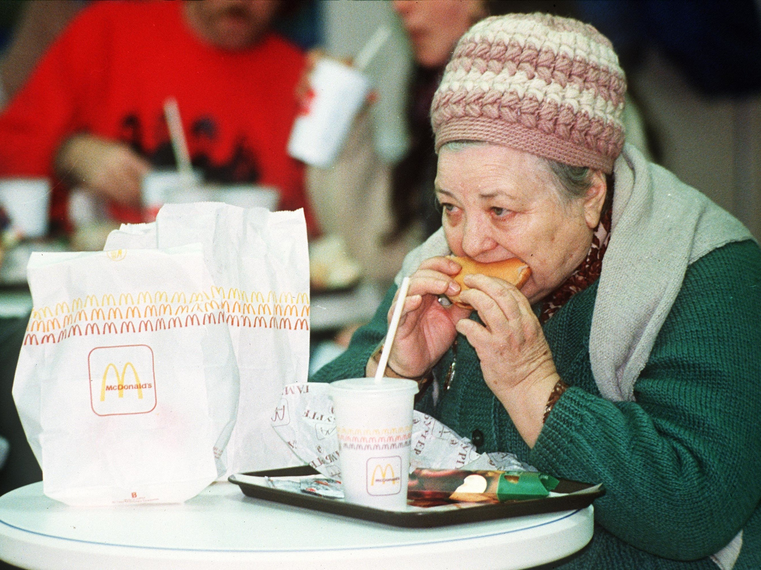 An elderly Russian woman eats a hamburger at the first McDonald's in the then Soviet Union on its opening day in January 1990. (ASSOCIATED PRESS)