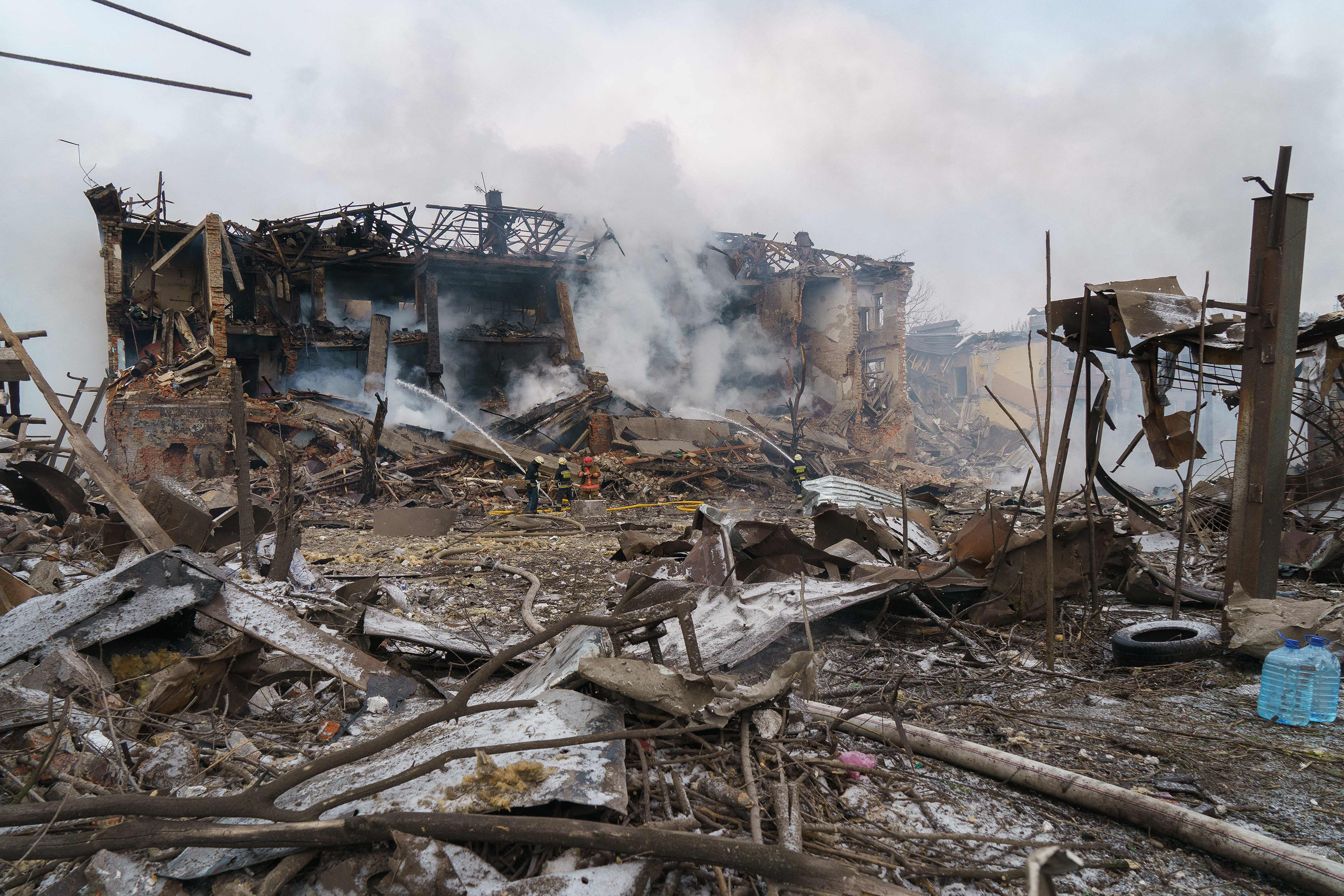 March 11: Firefighters spray water onto a destroyed shoe factory following an airstrike in Dnipro, Ukraine. Russian forces shelled a number of civilian targets Friday, leaving at least one dead, emergency services said, in what appeared to be the first direct attack on the city.