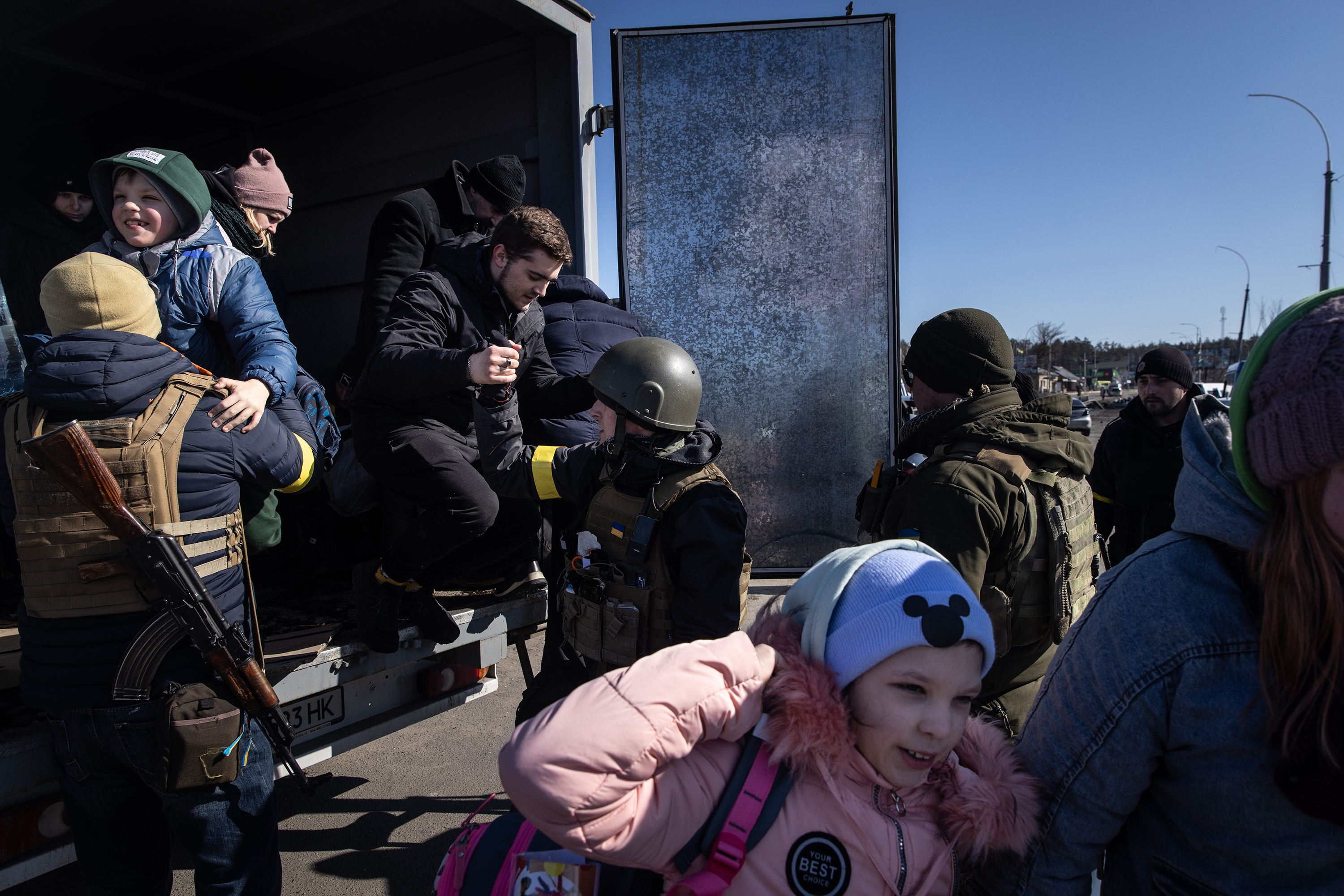 March 10: Residents of Irpin and Bucha, Ukraine, who are fleeing the area are helped out of a truck by members of the Ukrainian military as they prepare to cross a destroyed bridge in Irpin.