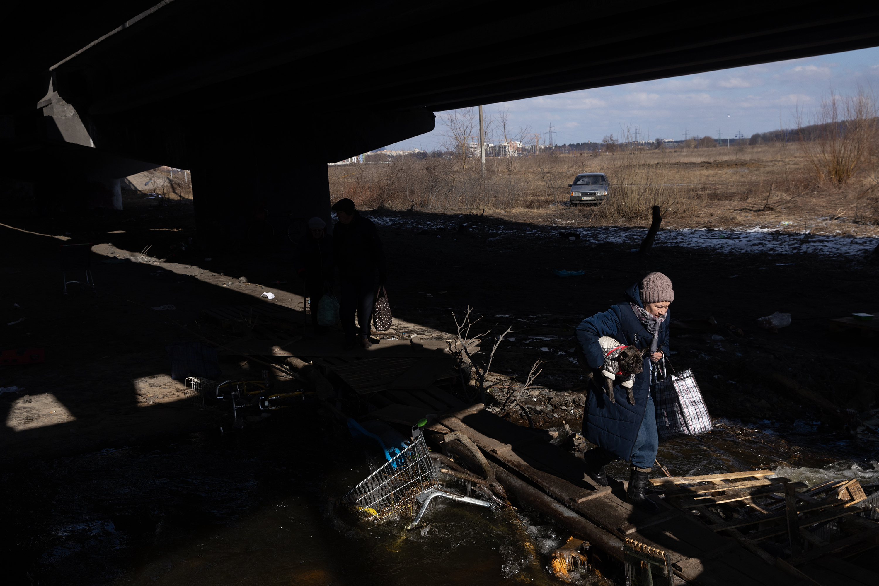March 10: Residents of Irpin and Bucha, Ukraine, flee the fighting across a destroyed bridge in Irpin.