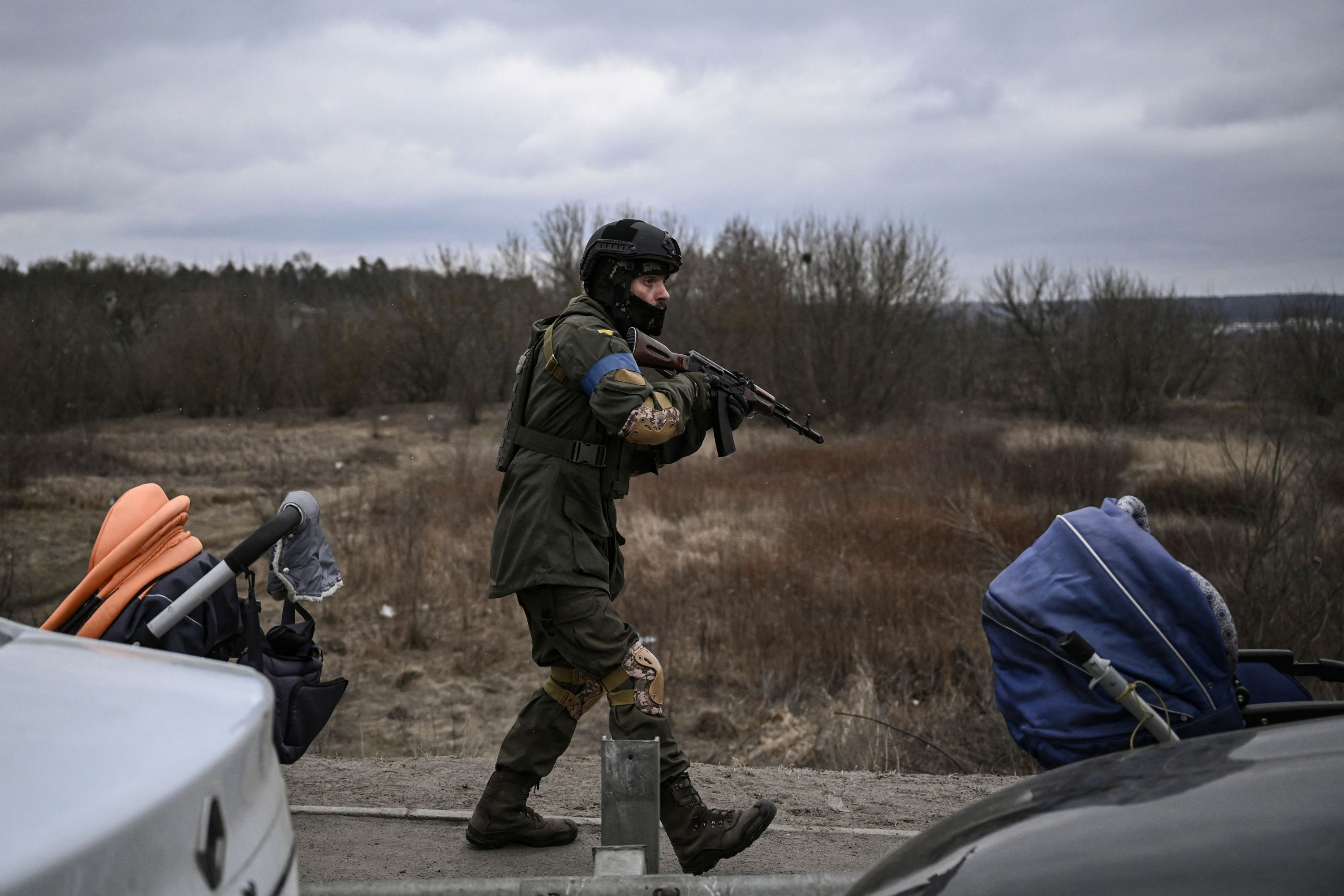 March 13: A Ukrainian serviceman walks carefully with his weapon in the city of Irpin. Russian forces advance ever closer to the capital from the north, west and northeast. Russian strikes also destroy an airport in the town of Vasylkiv, south of Kyiv.