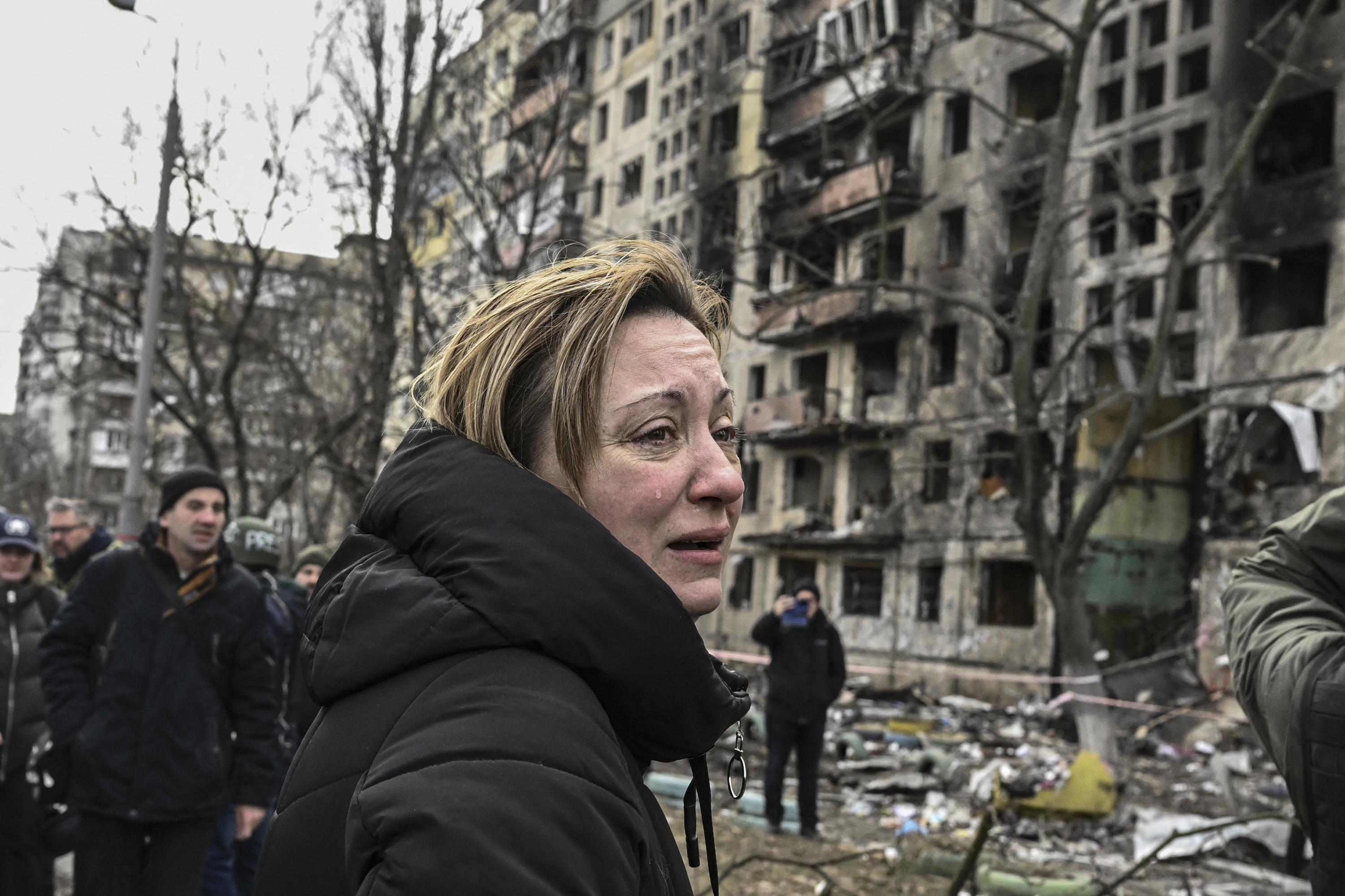 March 14: A woman reacts as she stands outside a ruined apartment building after it was shelled by Russian forces in the northwestern Obolon district of Kyiv, Ukraine.
