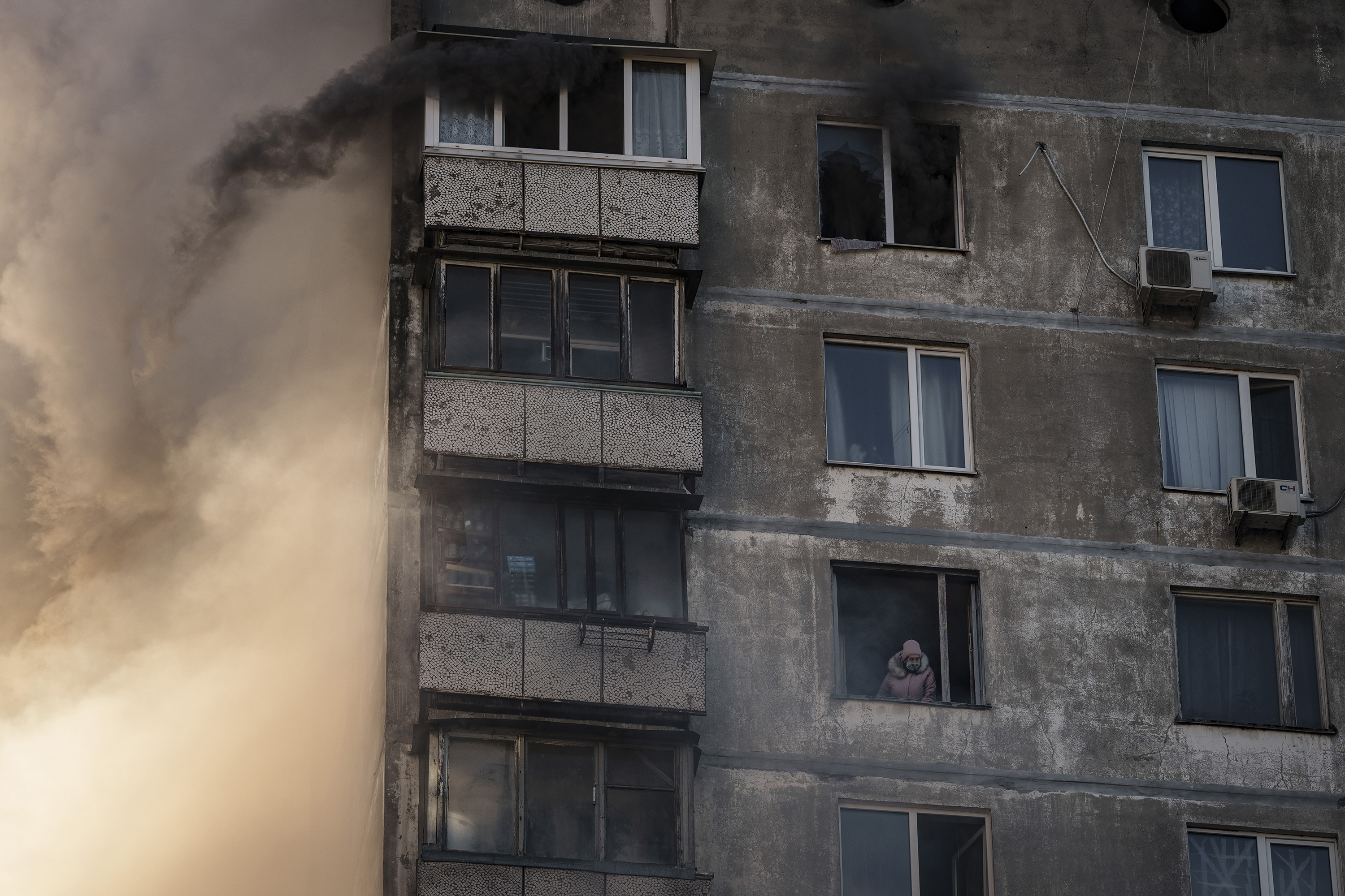 March 15: An elderly resident waits to be rescued by firefighters after the apartment building was hit by shelling in Kyiv, Ukraine.