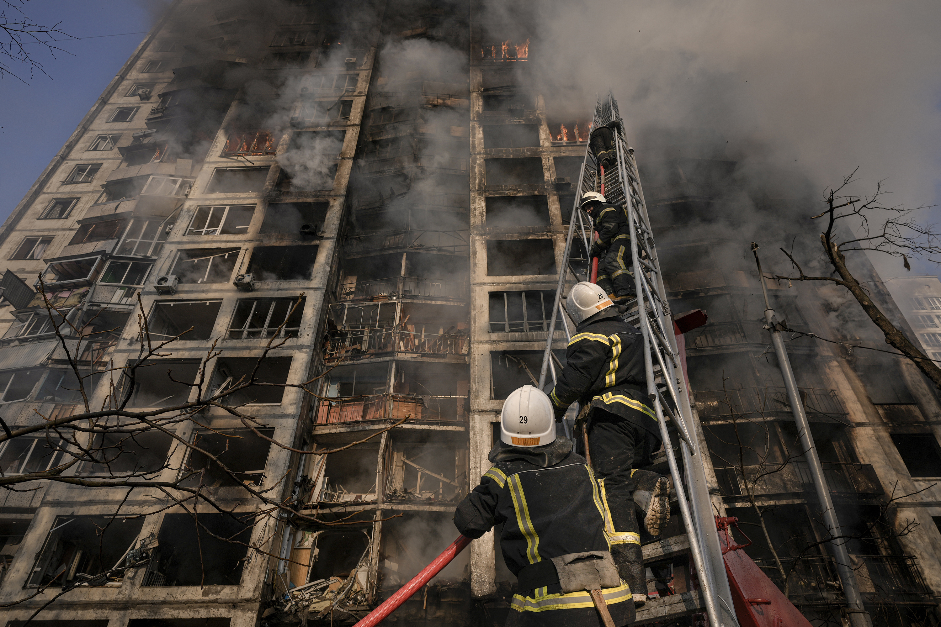 March 15: Firefighters climb a ladder while working to extinguish a blaze in a bombed out apartment building in a residential area of Kyiv, Ukraine.