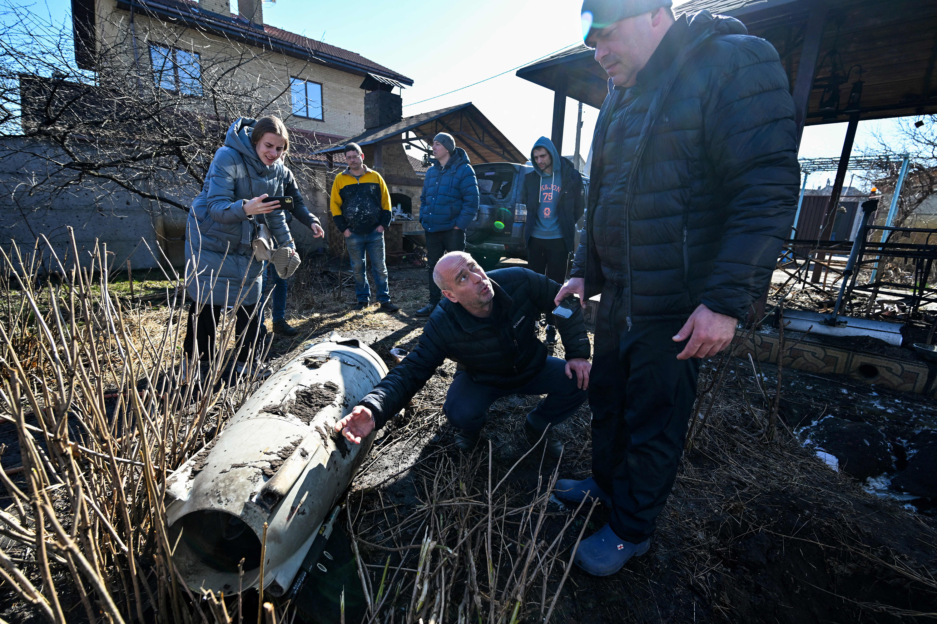 March 15: Neighbors examine the remains of a missile in the yard of a private house hit by shelling in the Osokorky District of Kyiv, Ukraine.