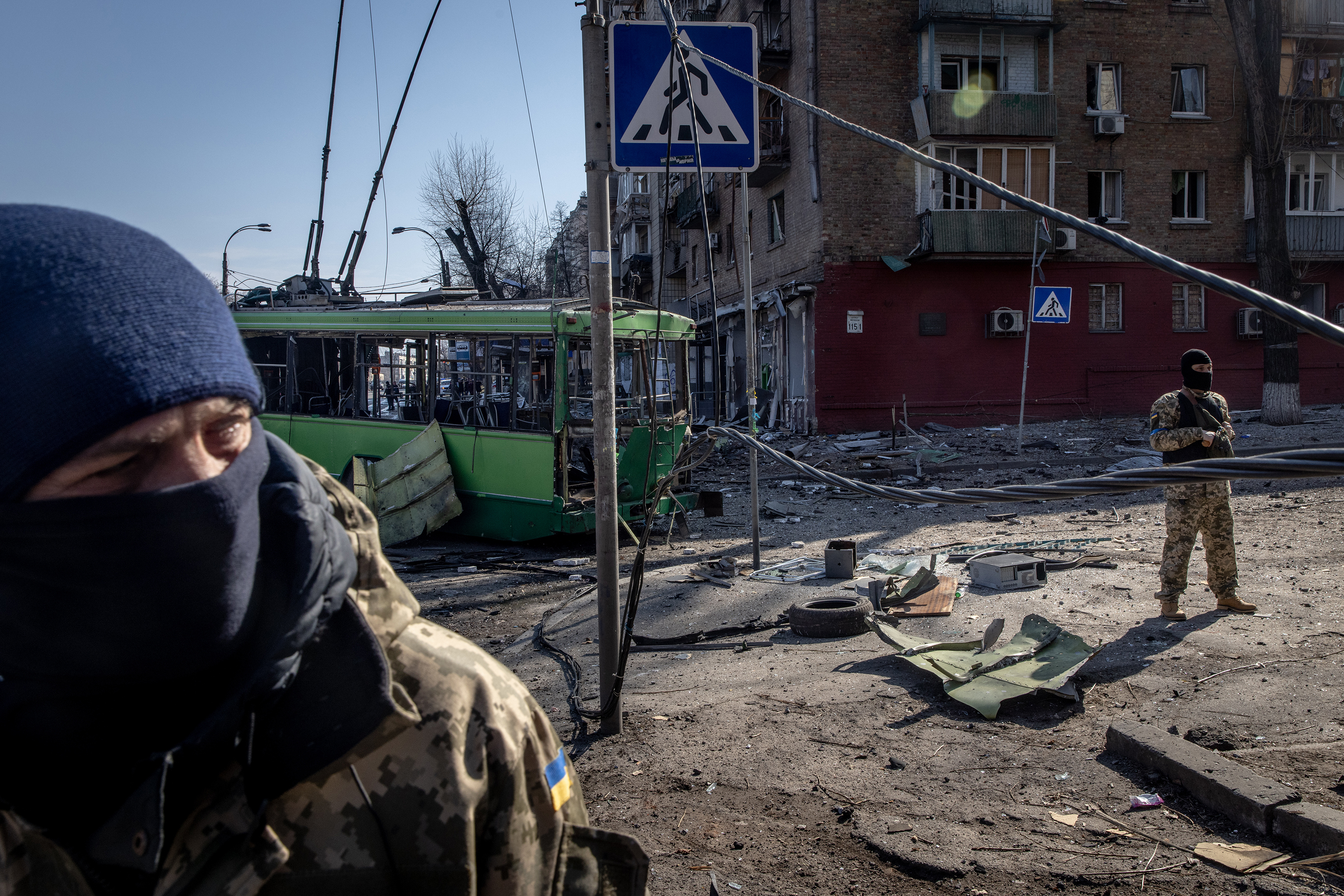 March 14: Members of the Ukrainian military stand amid debris from an apartment block struck by a Russian rocket that was shot down by Ukrainian air defenses in Kyiv, Ukraine.