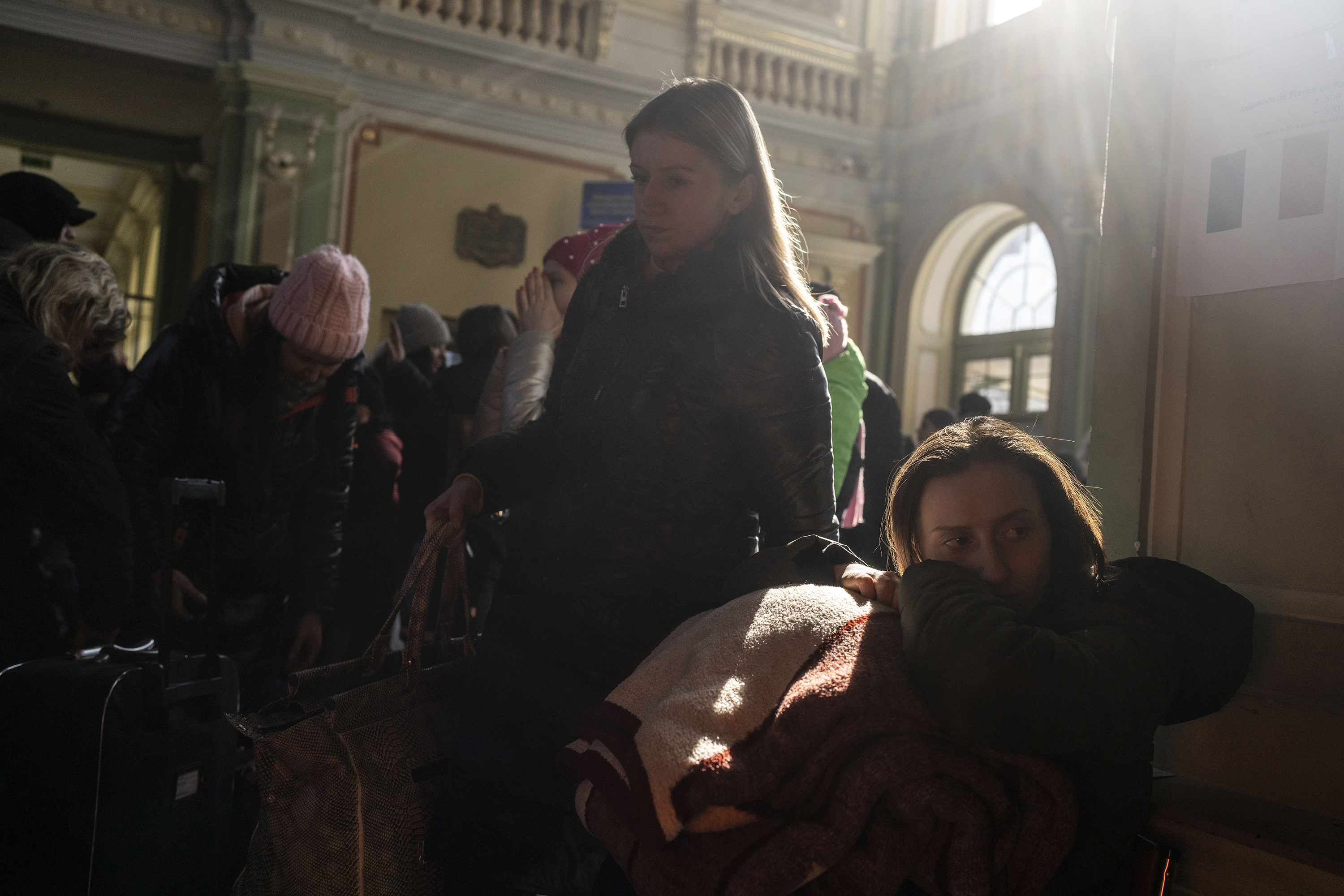 March 17: People who fled the war in Ukraine wait at the train station in Przemysl, Poland. Russia's invasion entered its fourth week on Thursday, with Russian forces largely bogged down outside major cities and shelling them from a distance, raining havoc on the civilians who still live there.