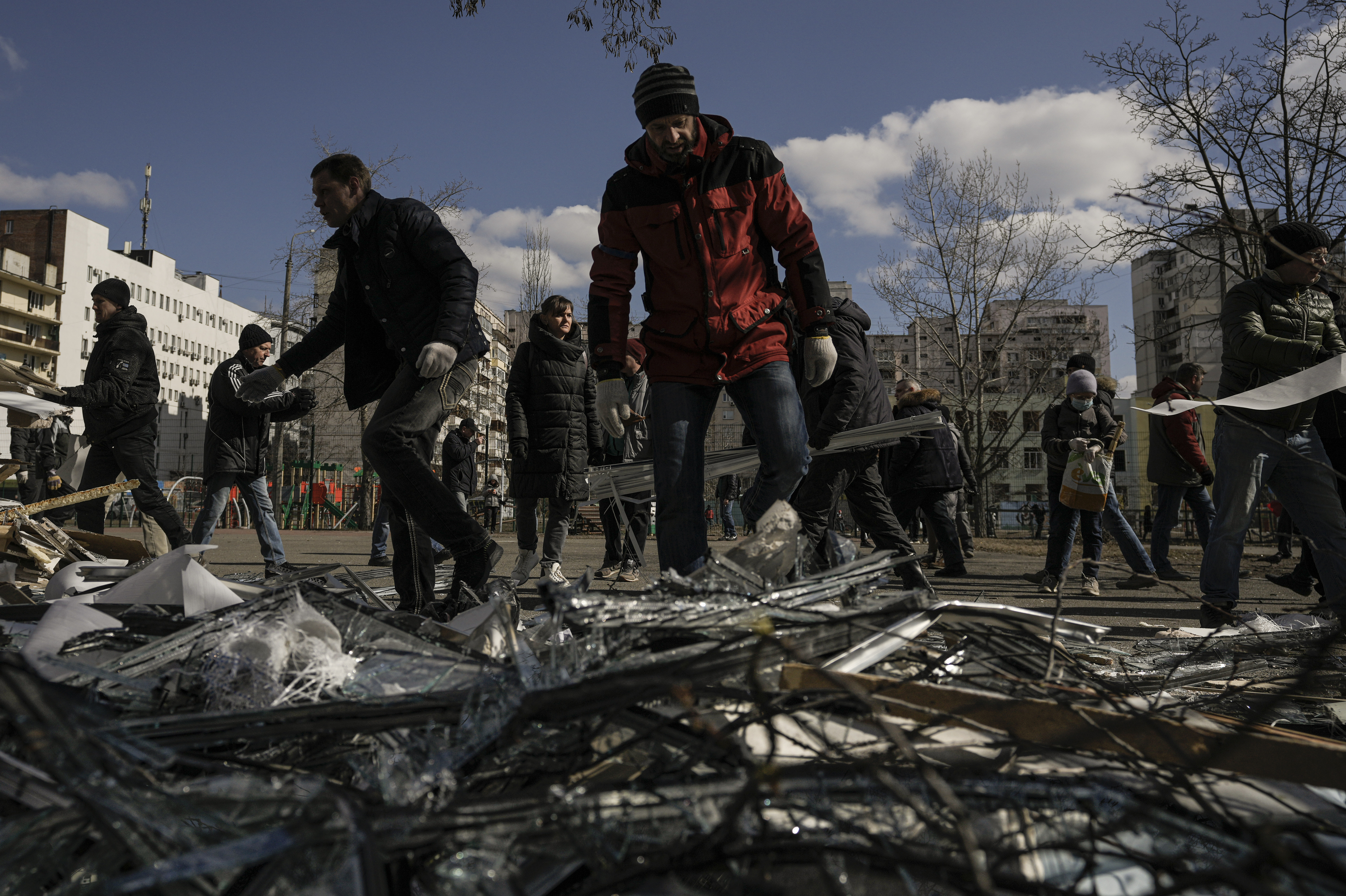 March 17: People clear debris outside a medical center damaged after parts of a Russian missile, shot down by Ukrainian air defense, landed on a nearby apartment block in Kyiv, according to authorities.