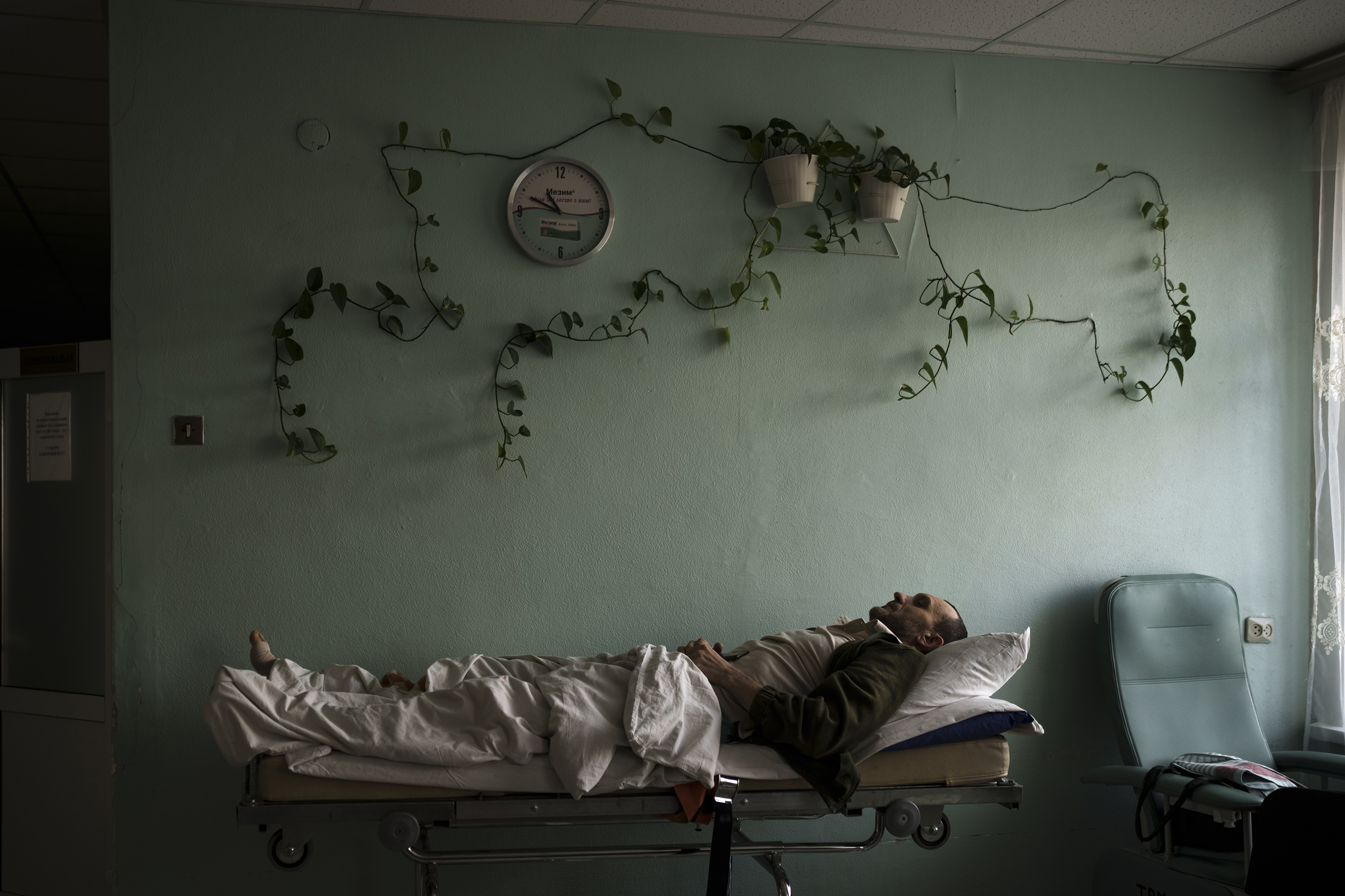March 17: A man injured in a bombing lies on a stretcher in a hospital hallway during an air raid alarm in Brovary, north of Kyiv.