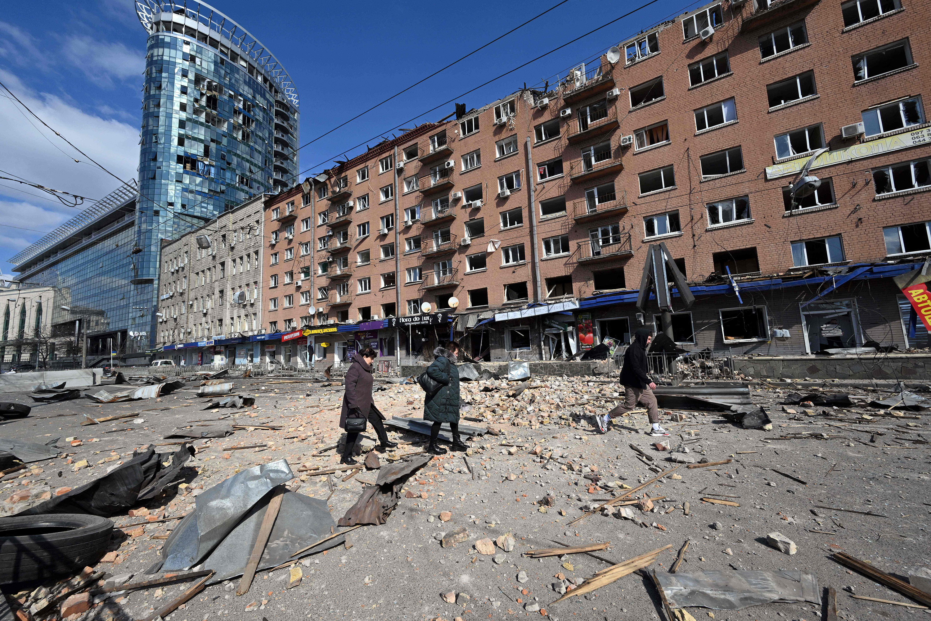 March 17: People walk by a building in Kyiv damaged by Russian shelling as Russian troops try to encircle the nation's capital as part of their slow-moving offensive.