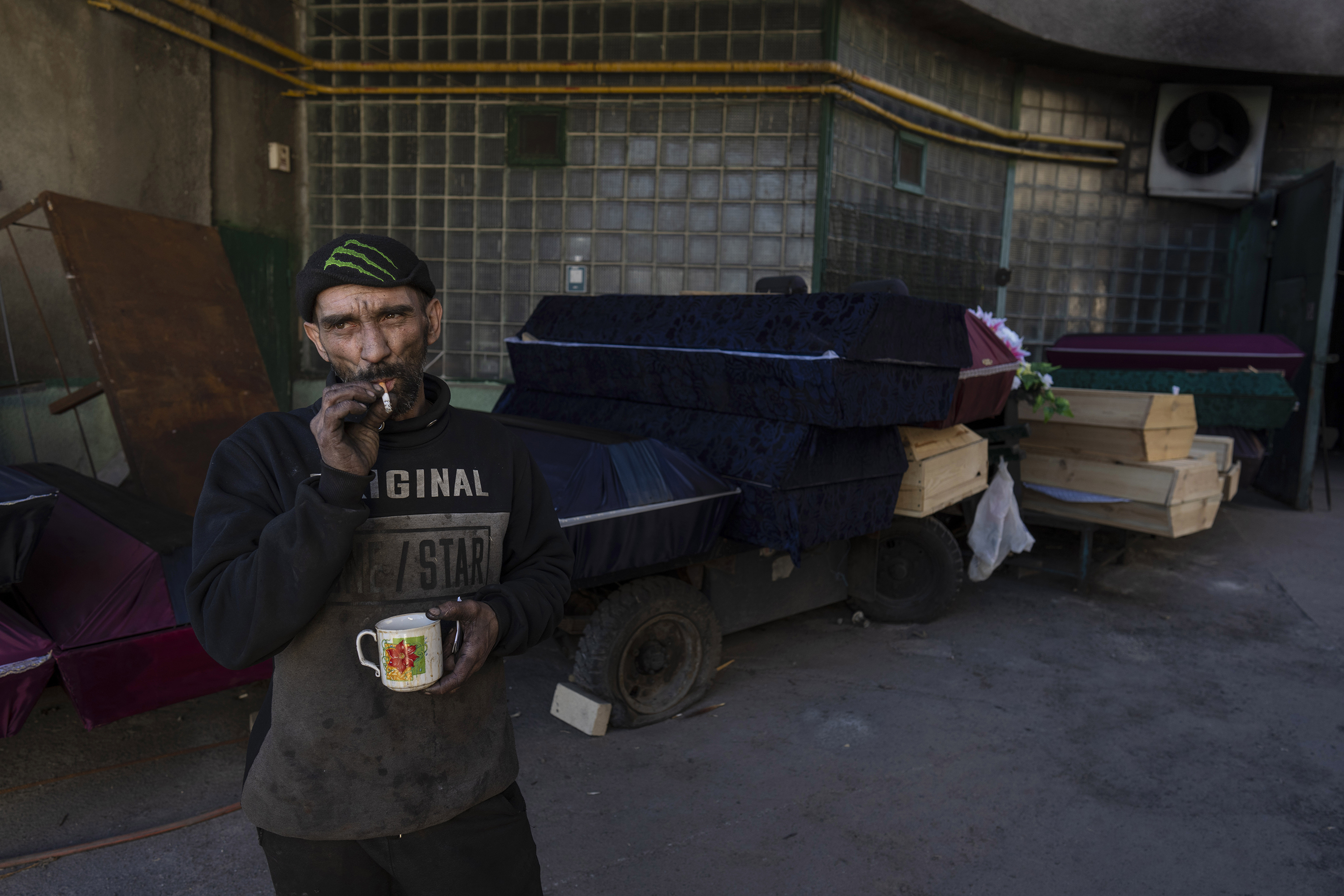 March 21: Ruslan Trishchuk, 40, smokes a cigarette while taking a break outside the Baikave cemetery's crematorium in Kyiv.