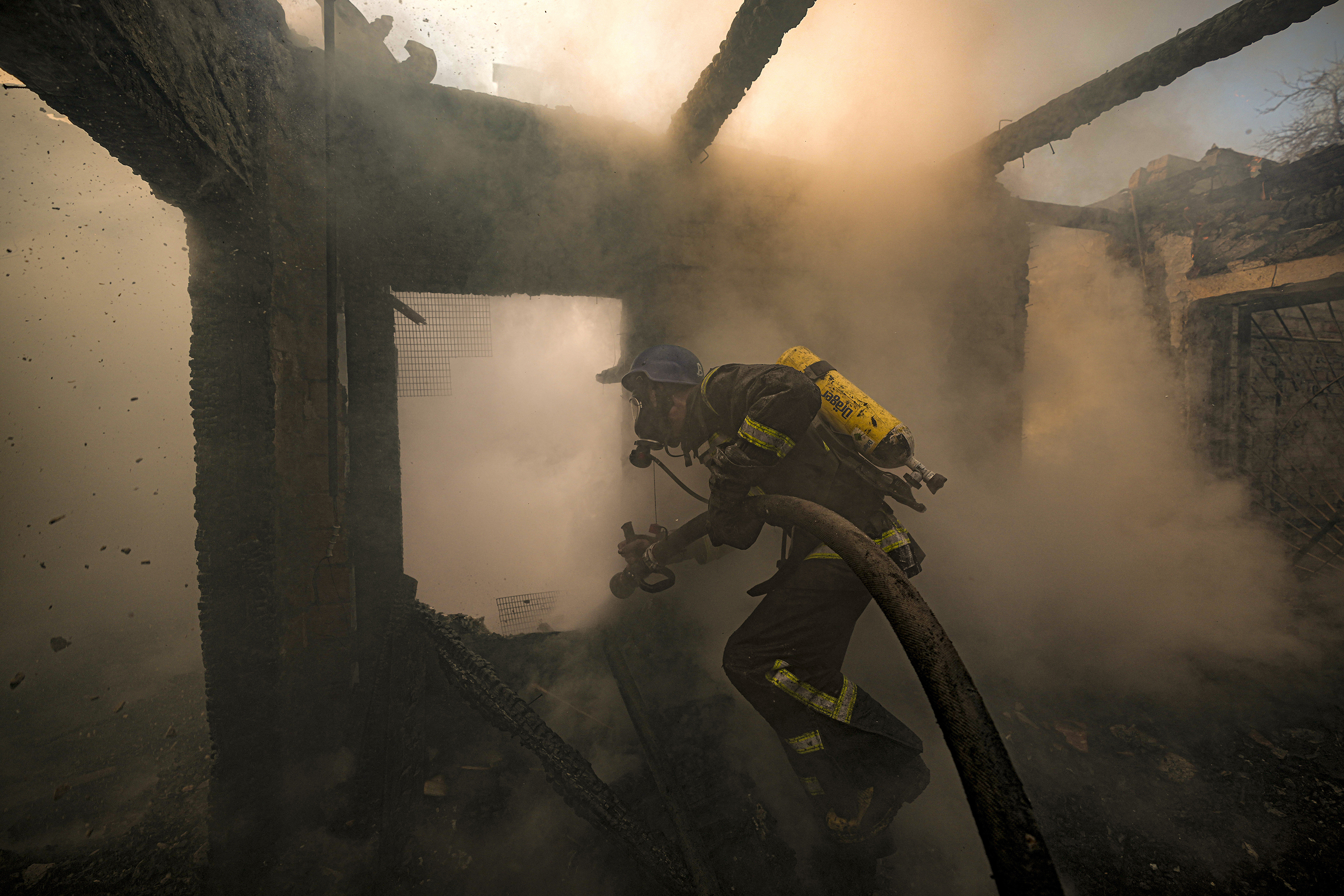 March 23: A firefighter douses a home in Kyiv that was destroyed by Russian shelling.