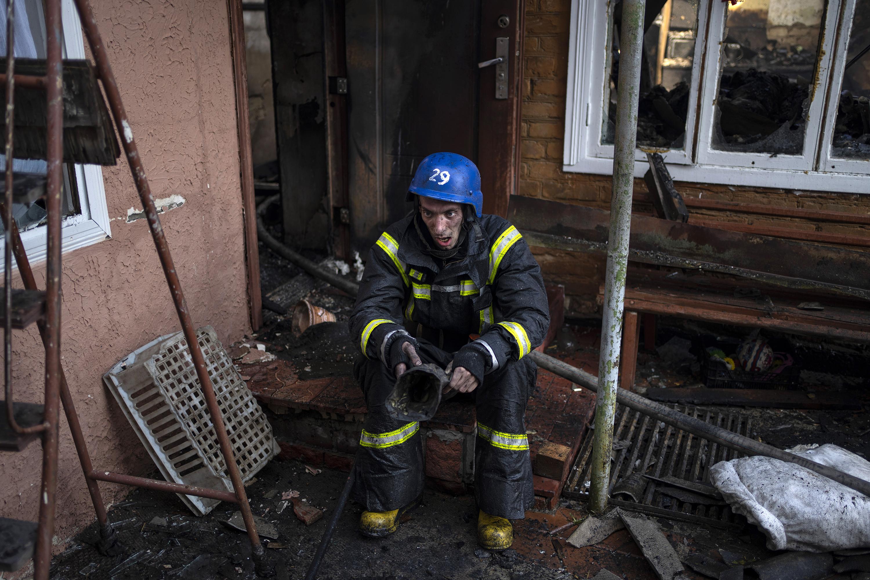 March 23: A firefighter takes a break from extinguishing a fire inside a home destroyed by shelling in Kyiv.