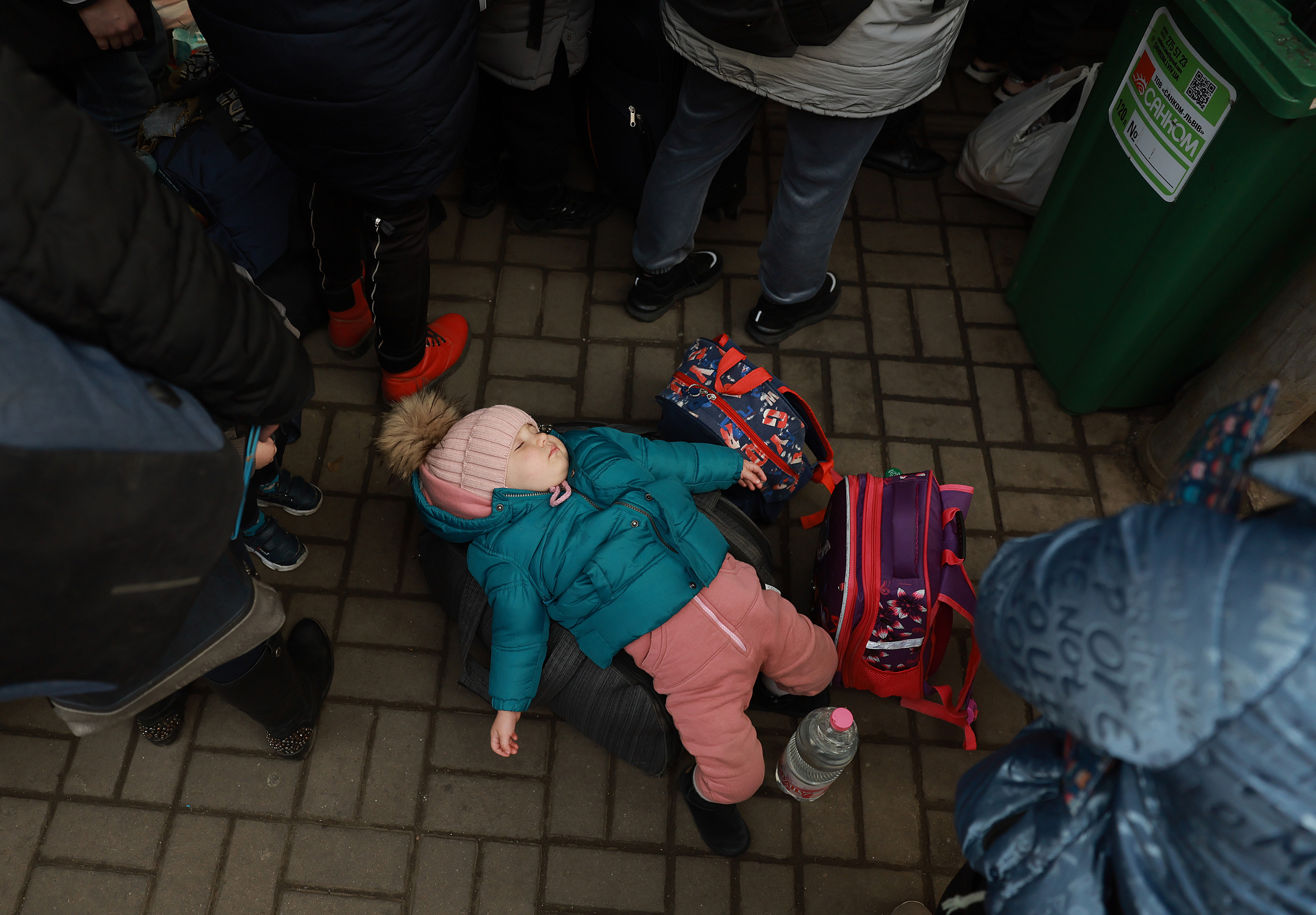 March 23: Sophia, 1, lies on a piece of luggage as she and her mother wait for a train to Poland at the main station in Lviv. Her mother said they'd fled from the city of Dnipr.