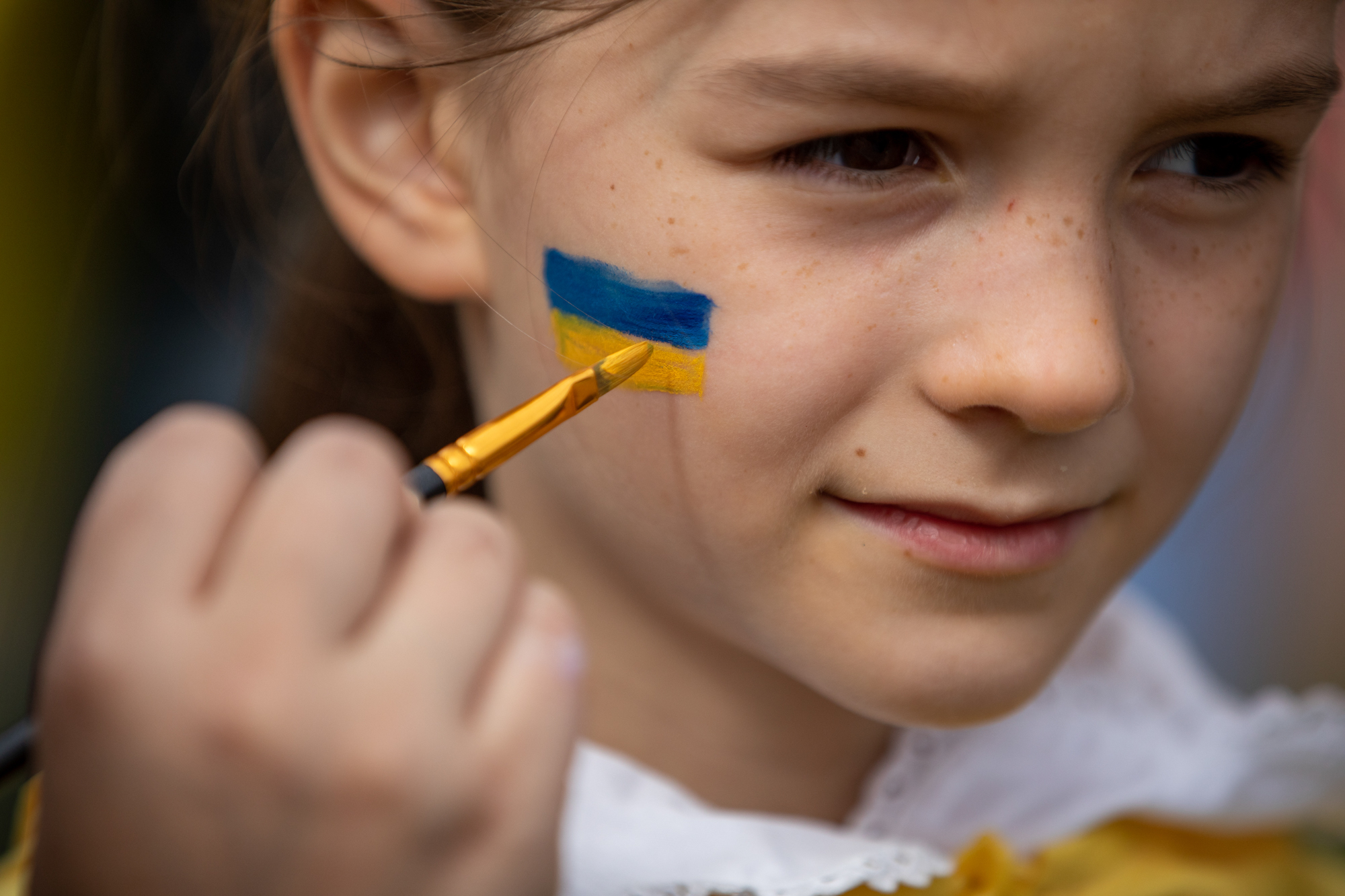 <strong>March 20:</strong> Rachel Nockles, 7, gets a Ukrainian flag painted on her face at a STANDwithUKRAINE rally in front of the White House. Her mother is from Ukraine, but her family now lives in Bethesda, Maryland. (WAMU)