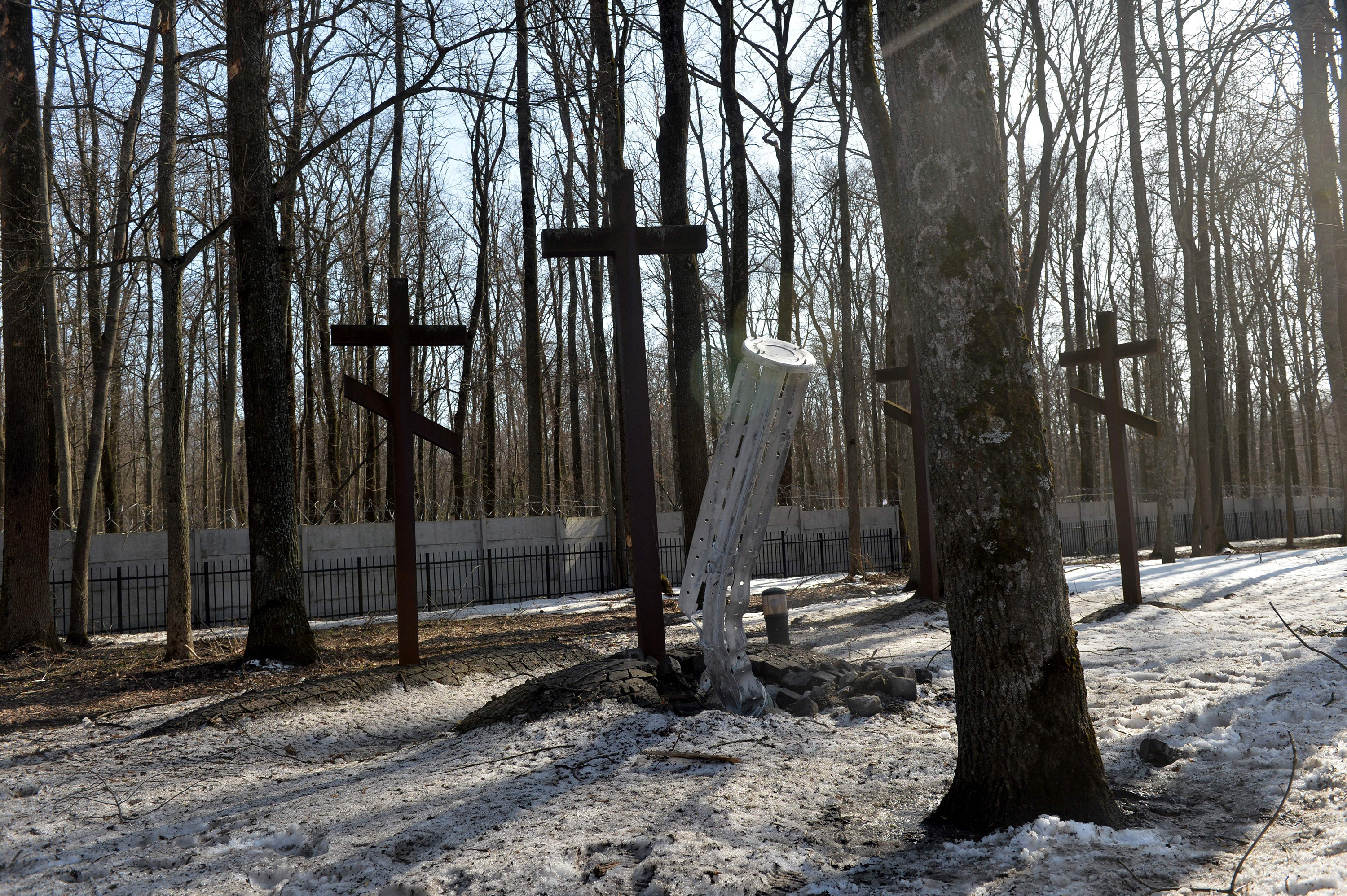 March 23: The internal components of a 300mm rocket are embedded in the ground next to graves after shelling near the Memorial to the Victims of Totalitarianism in a forest on the outskirts of Kharkiv.