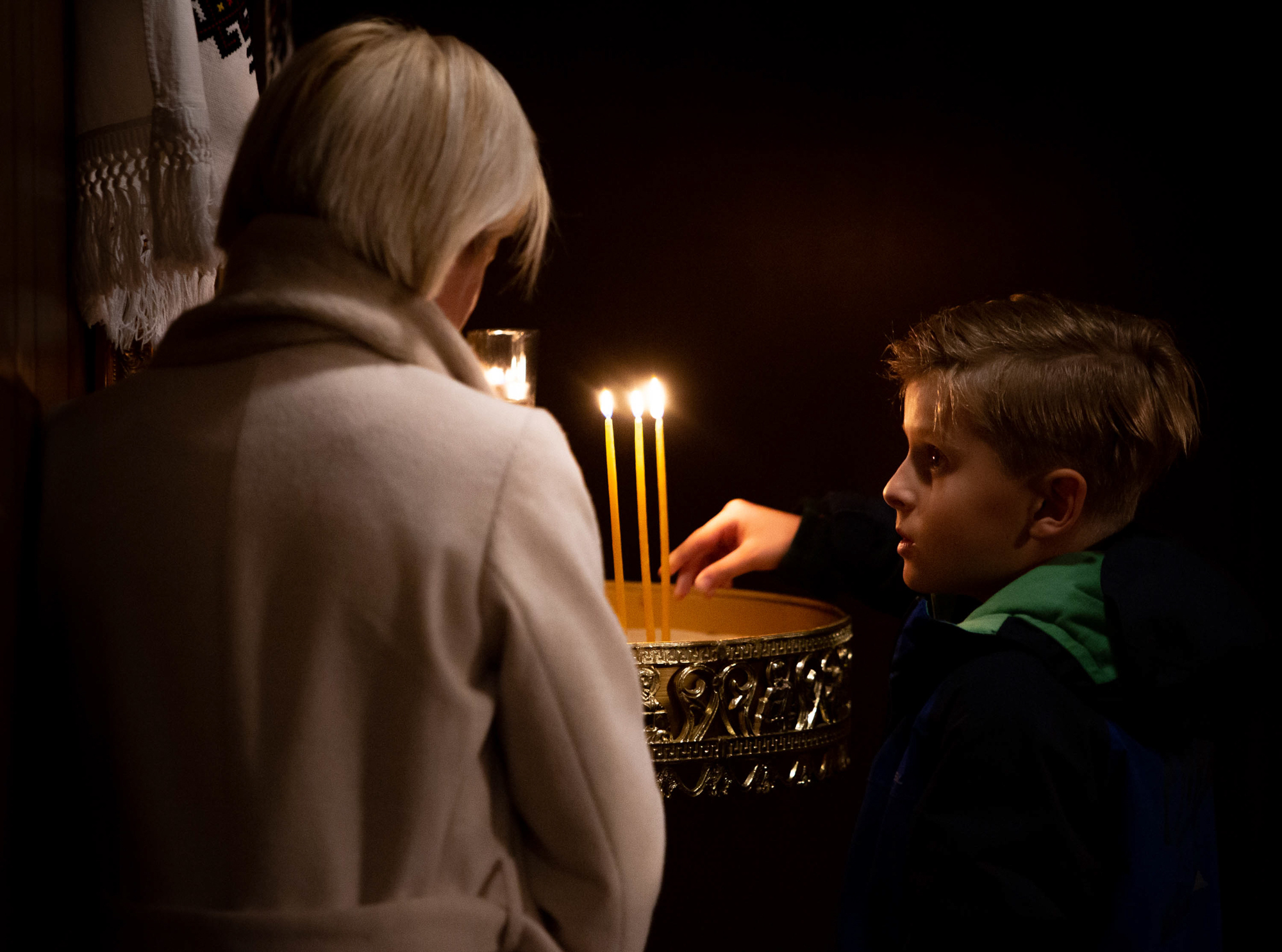 Feb. 25: Nataliya Ovod of St. Louis, Missouri, lights candles alongside her son, Antony, at St. Mary's Assumption Ukrainian Church in south St. Louis County. Russian forces had attacked Kyiv earlier in the day.