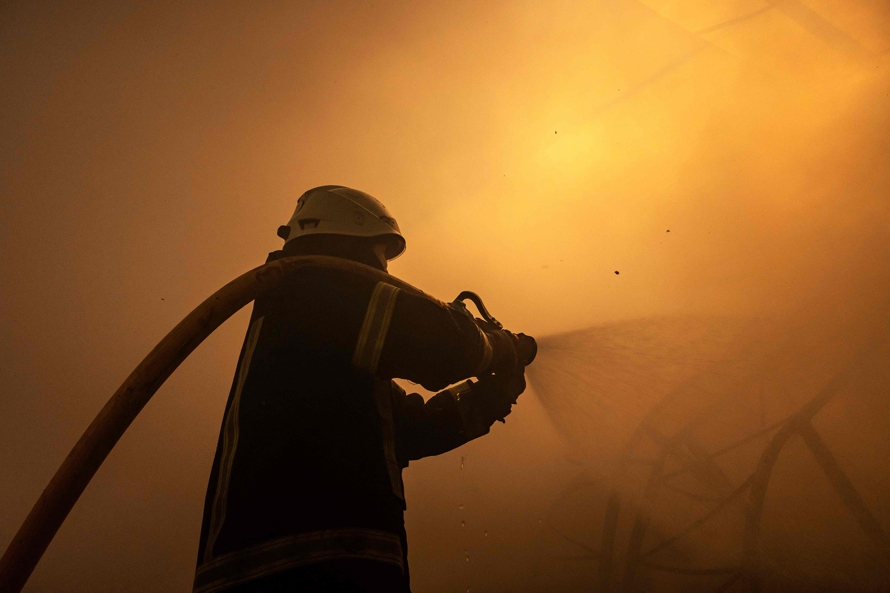 March 24: A firefighter fights a fire after Russian attacks struck a warehouse in the suburbs of Kyiv.