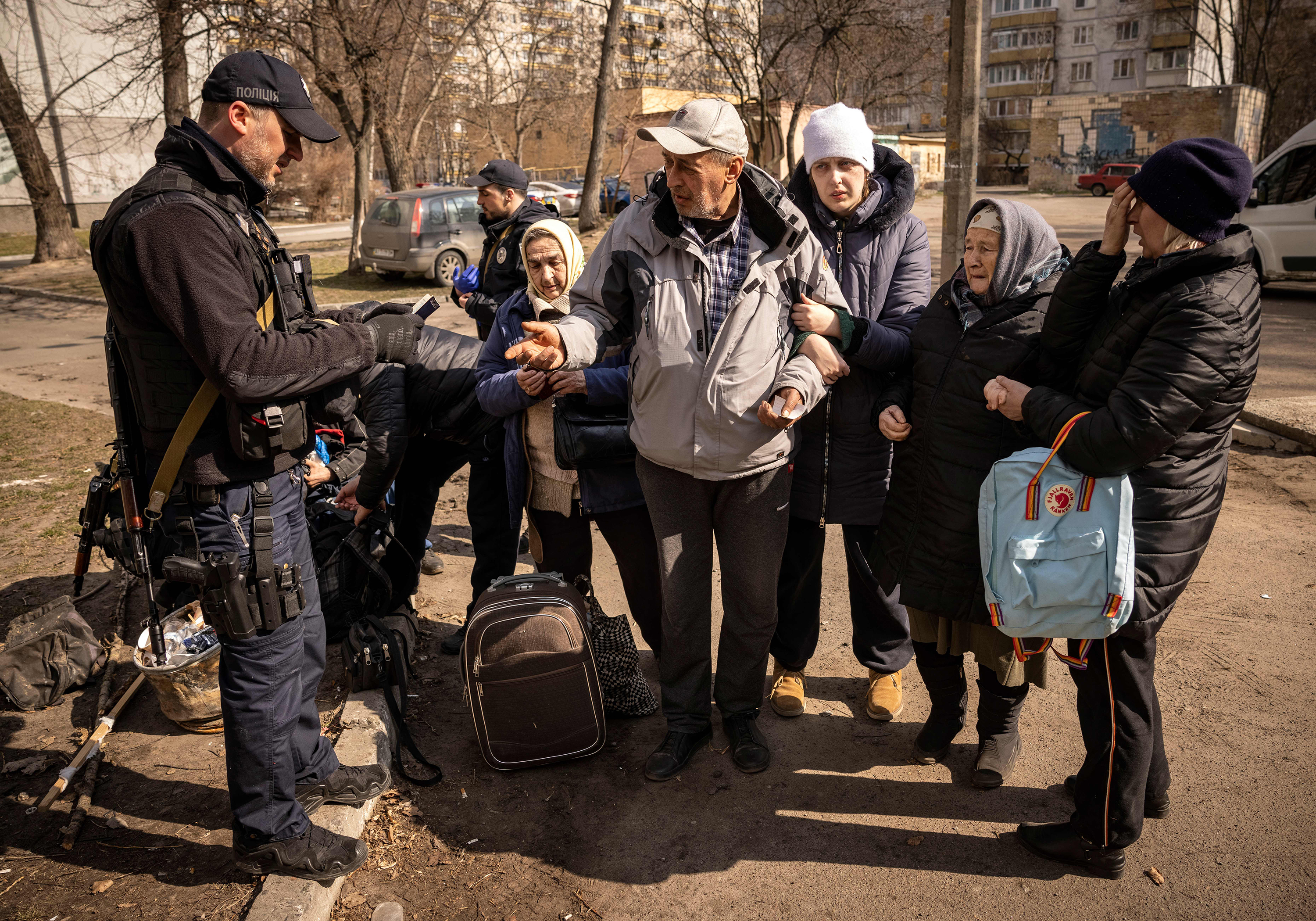 March 24: Displaced people fleeing the suburbs have their IDs checked in the Ukrainian capital Kyiv.