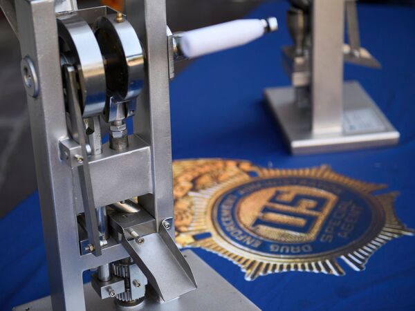 A pill press machine seized by authorities is displayed during a news conference outside the Roybal Federal Building in February 2021 in Los Angeles.