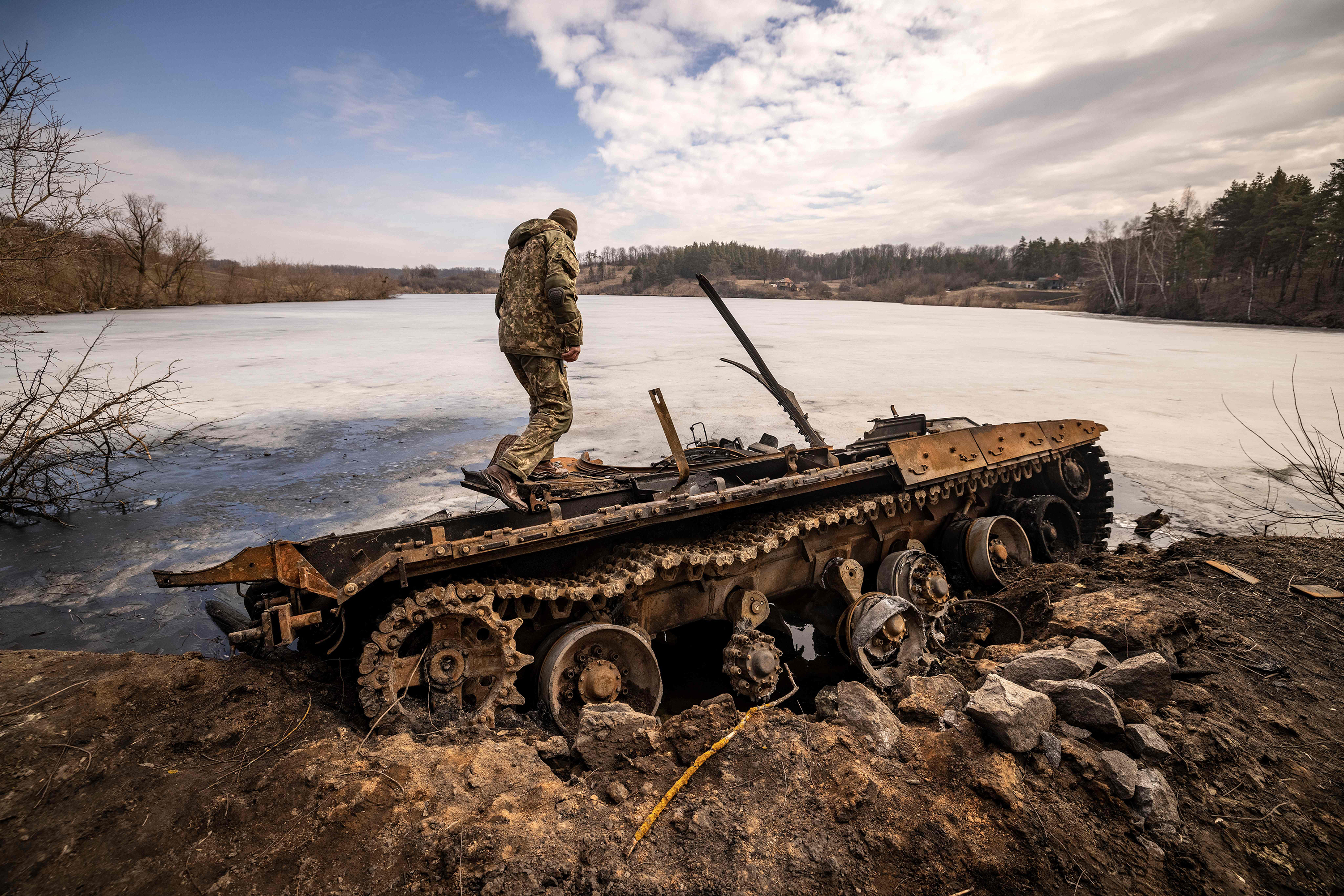 March 29: A Ukrainian serviceman stands near a destroyed Russian tank in Trostyanets.