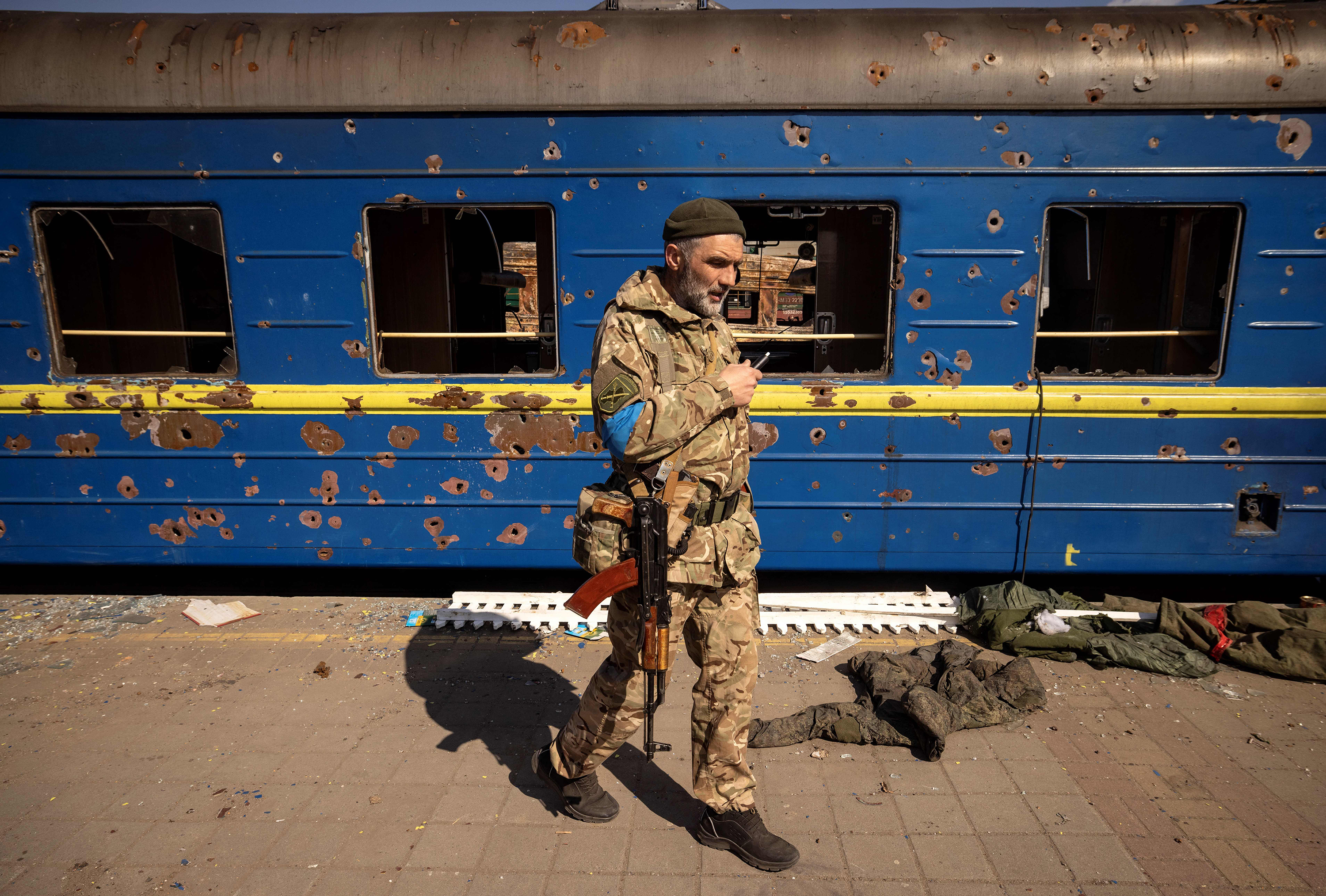 March 29: A Ukrainian serviceman walks near a damaged train in the northeastern city of Trostyanets.