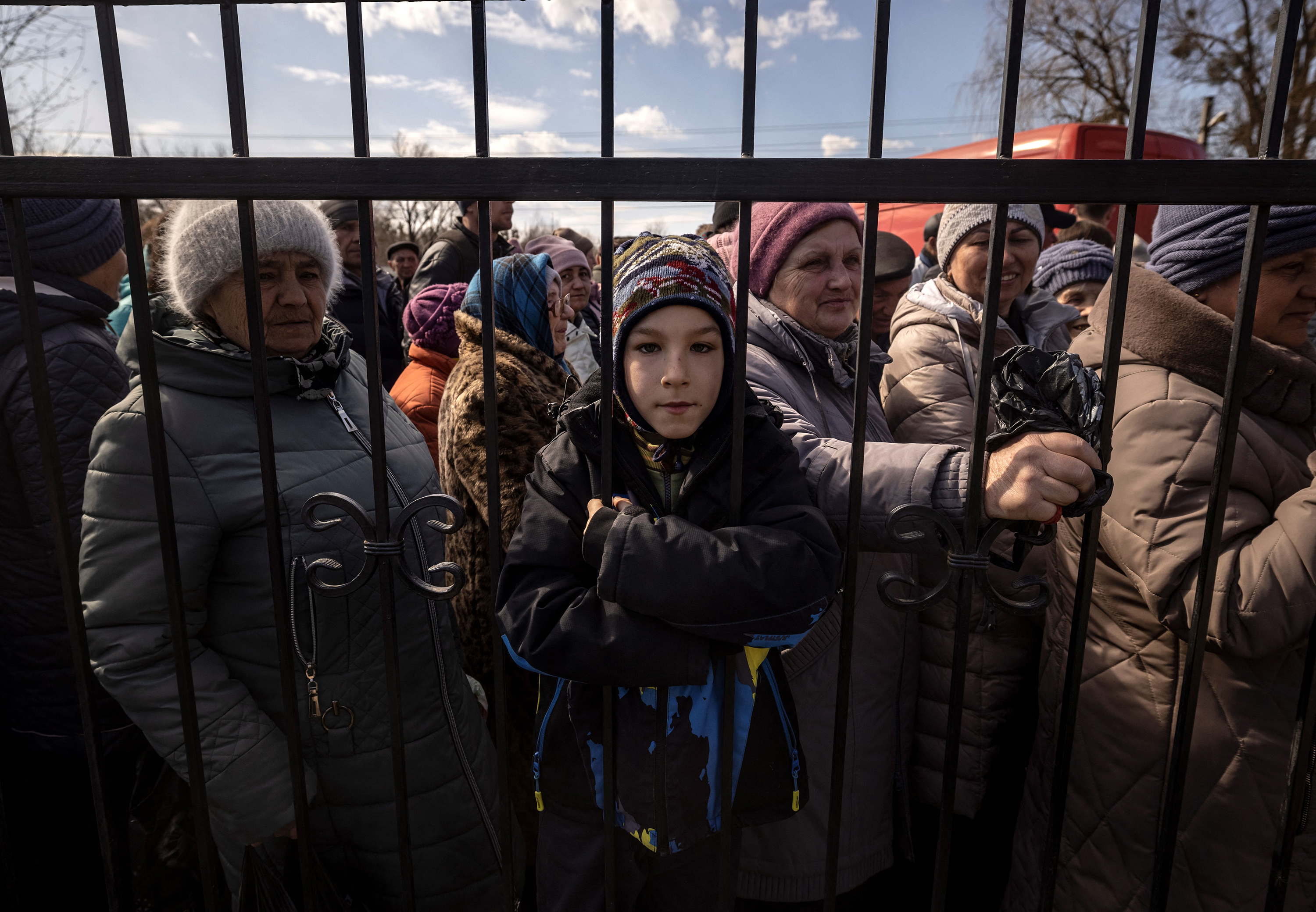March 29: Residents wait for food outside a church in the northeastern city of Trostyanets.