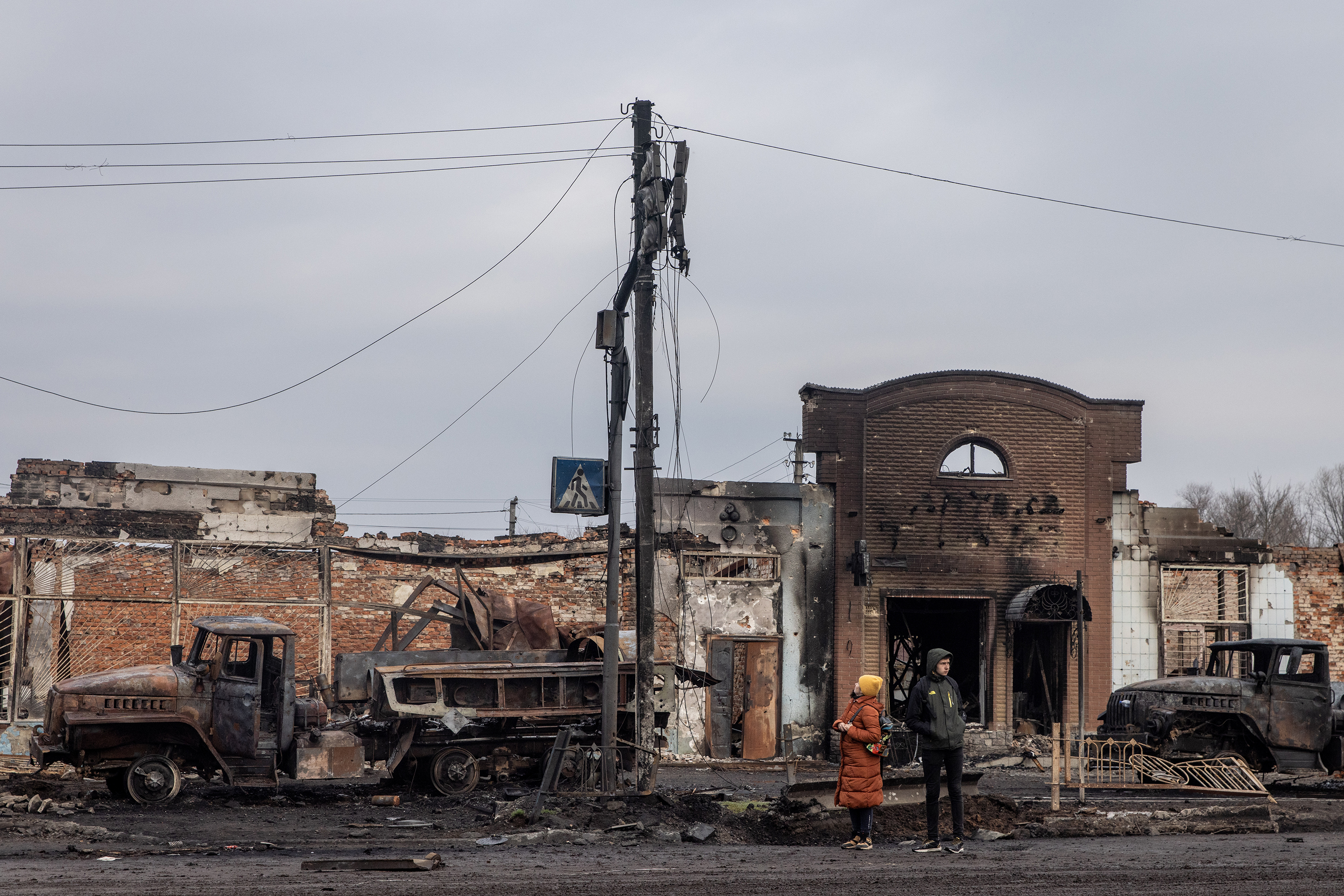 March 30: People stand amid destroyed Russian military vehicles close to the central train station that was used as a Russian base in Trostyanets.