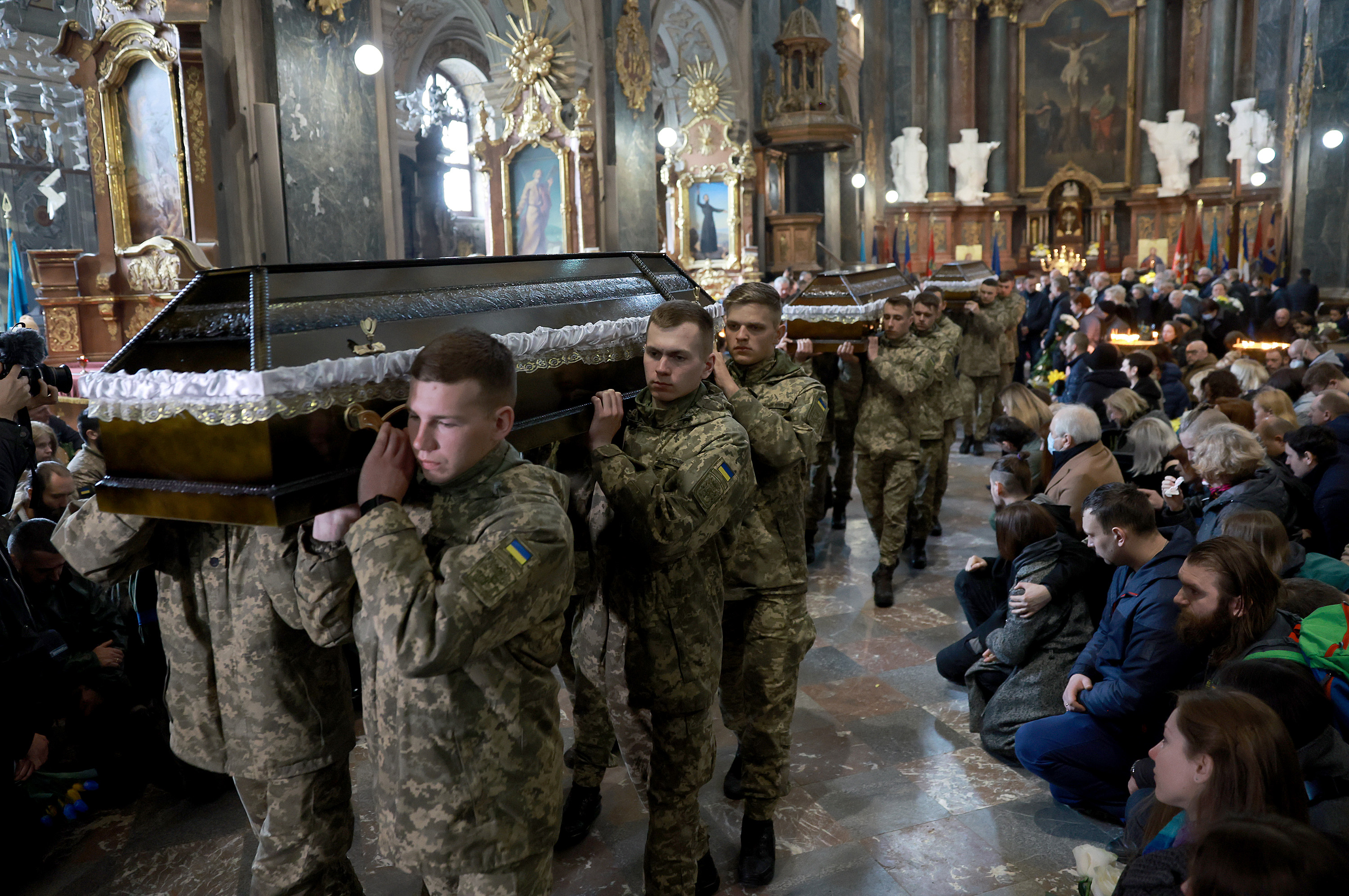 March 31: Ukrainian military members carry the caskets of three Ukrainian servicemen from the Church of the Most Holy Apostles Peter and Paul during their funerals in Lviv.