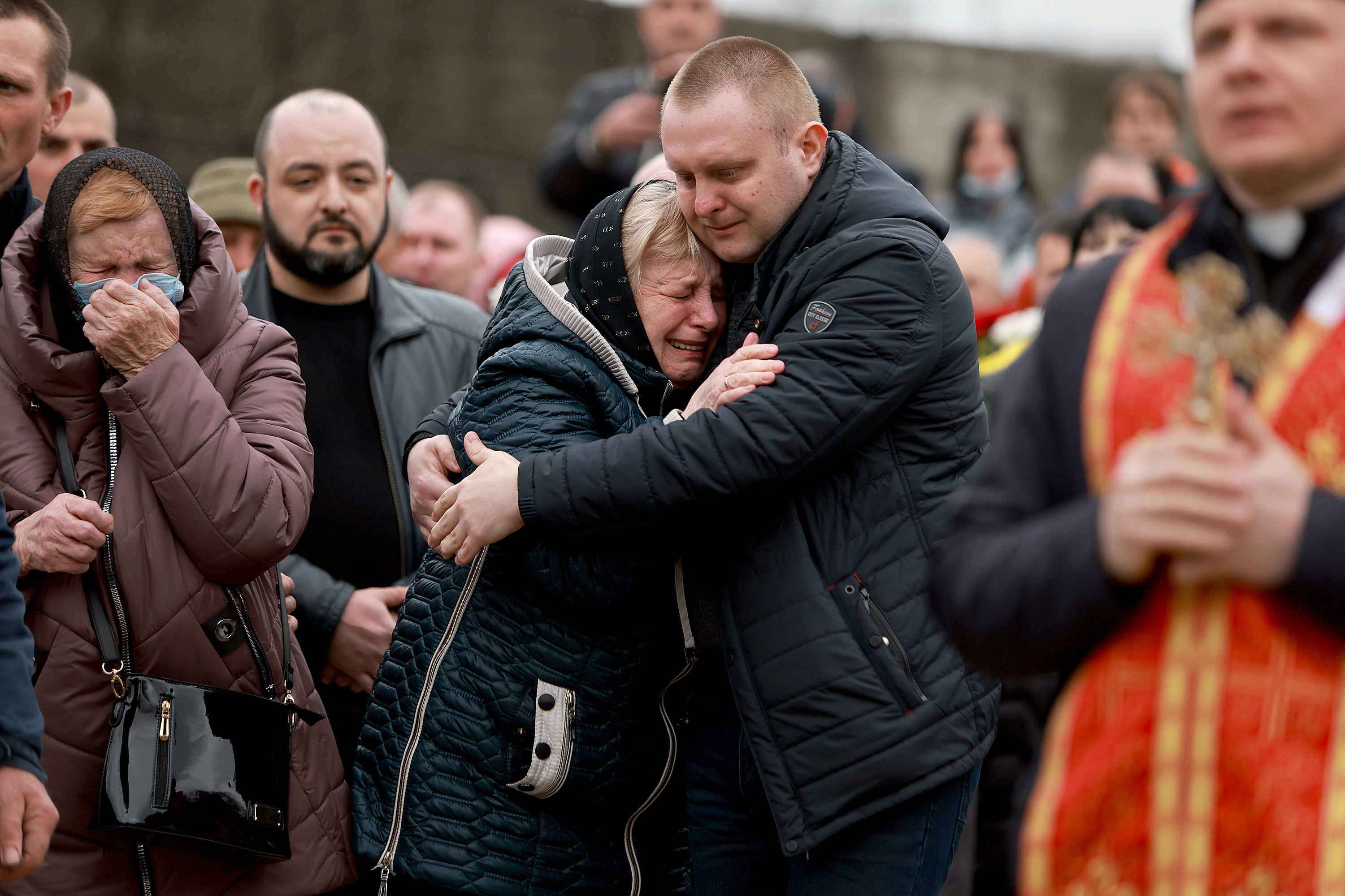 March 31: Relatives of Ukrainian military member Yuriy Oliynyk become emotional during his burial at the Lychakiv Cemetery in Lviv. Yuriy was buried alongside Igor Sargsyan and Andriy Kozachenko. Each was killed in separate incidents while fighting against the Russian military.
