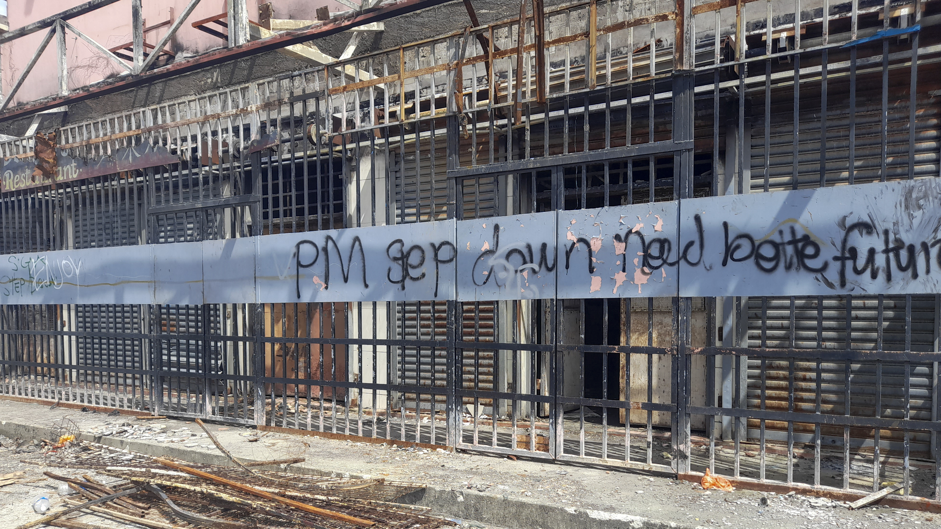 Graffiti written on the burnt out buildings from riots in Honiara