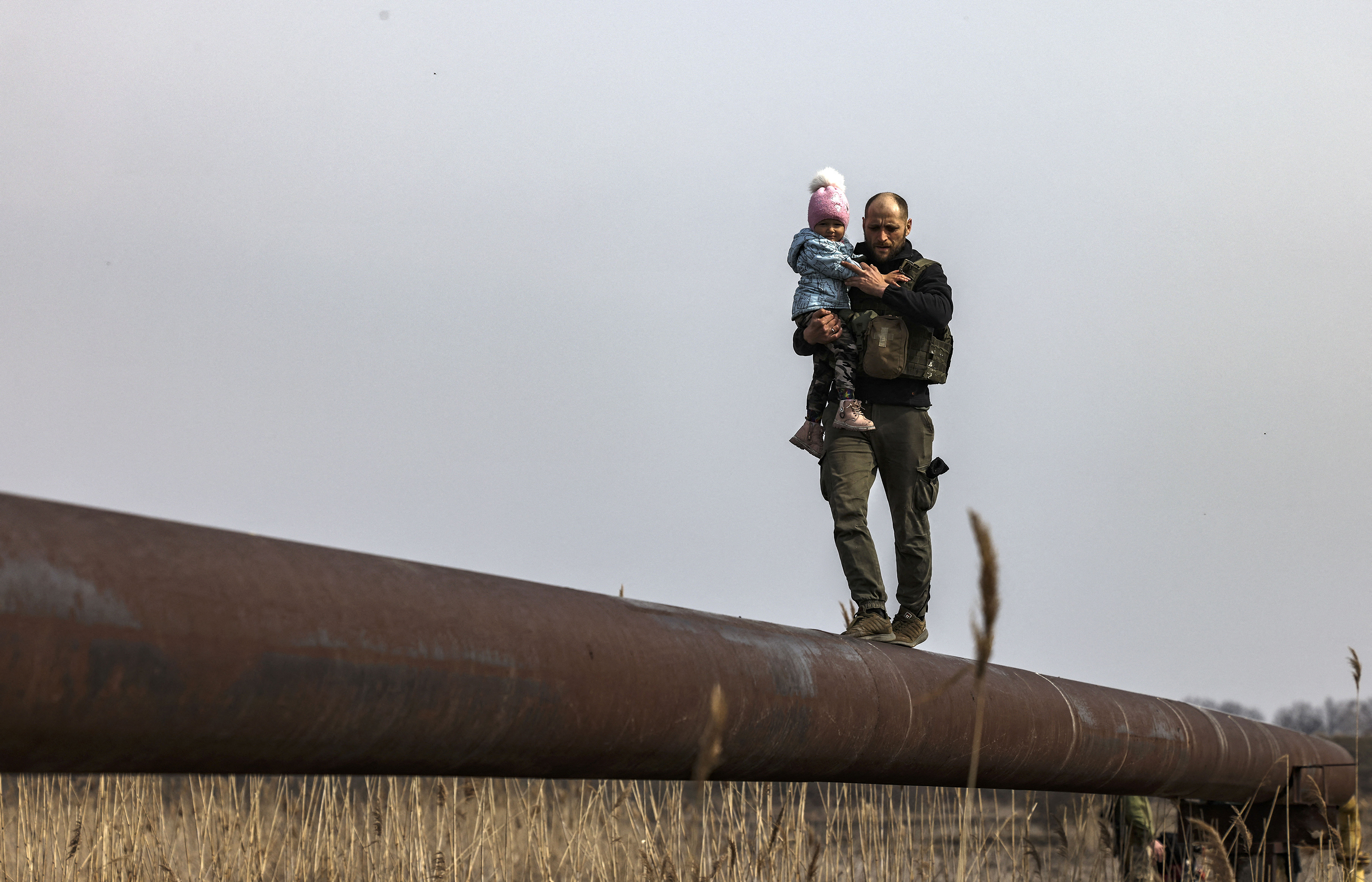 March 31: Ukrainian soldier Andriy carries the baby of a displaced family to help to cross a river, on the outskirts of Kyiv.