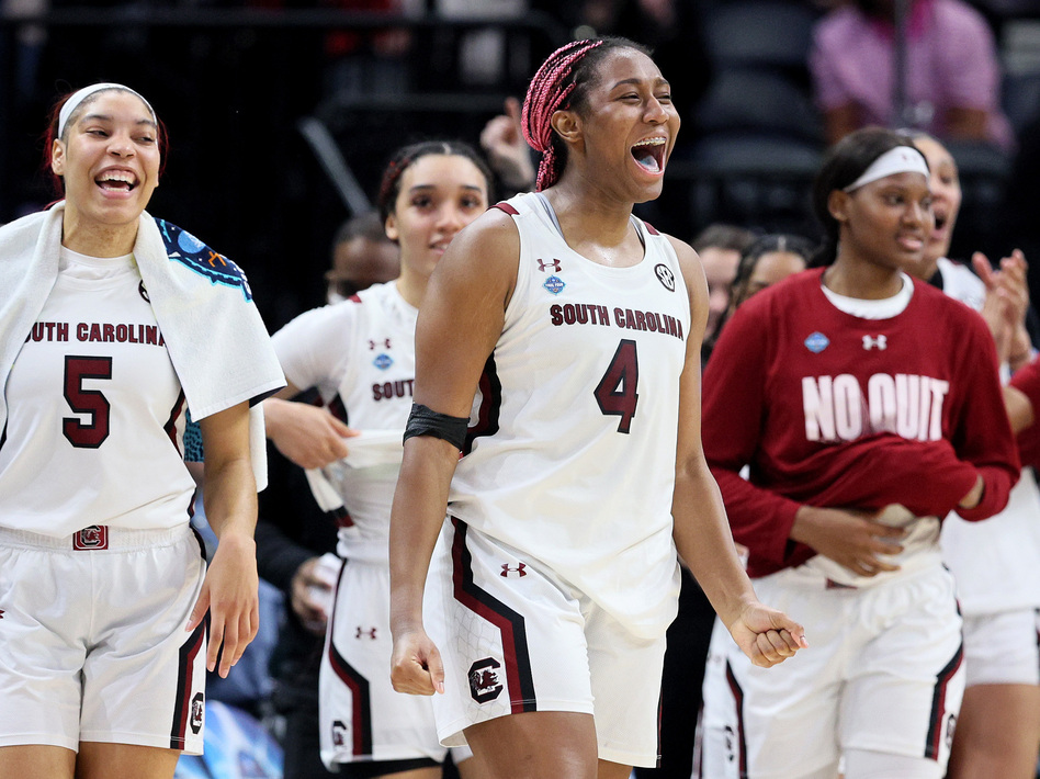 Victaria Saxton #5 and Aliyah Boston #4 of the South Carolina Gamecocks celebrate with teammates in the second half against the Louisville Cardinals during the 2022 NCAA Women's Final Four semifinal game Friday at Target Center. South Carolina defeated Louisville 72-59.