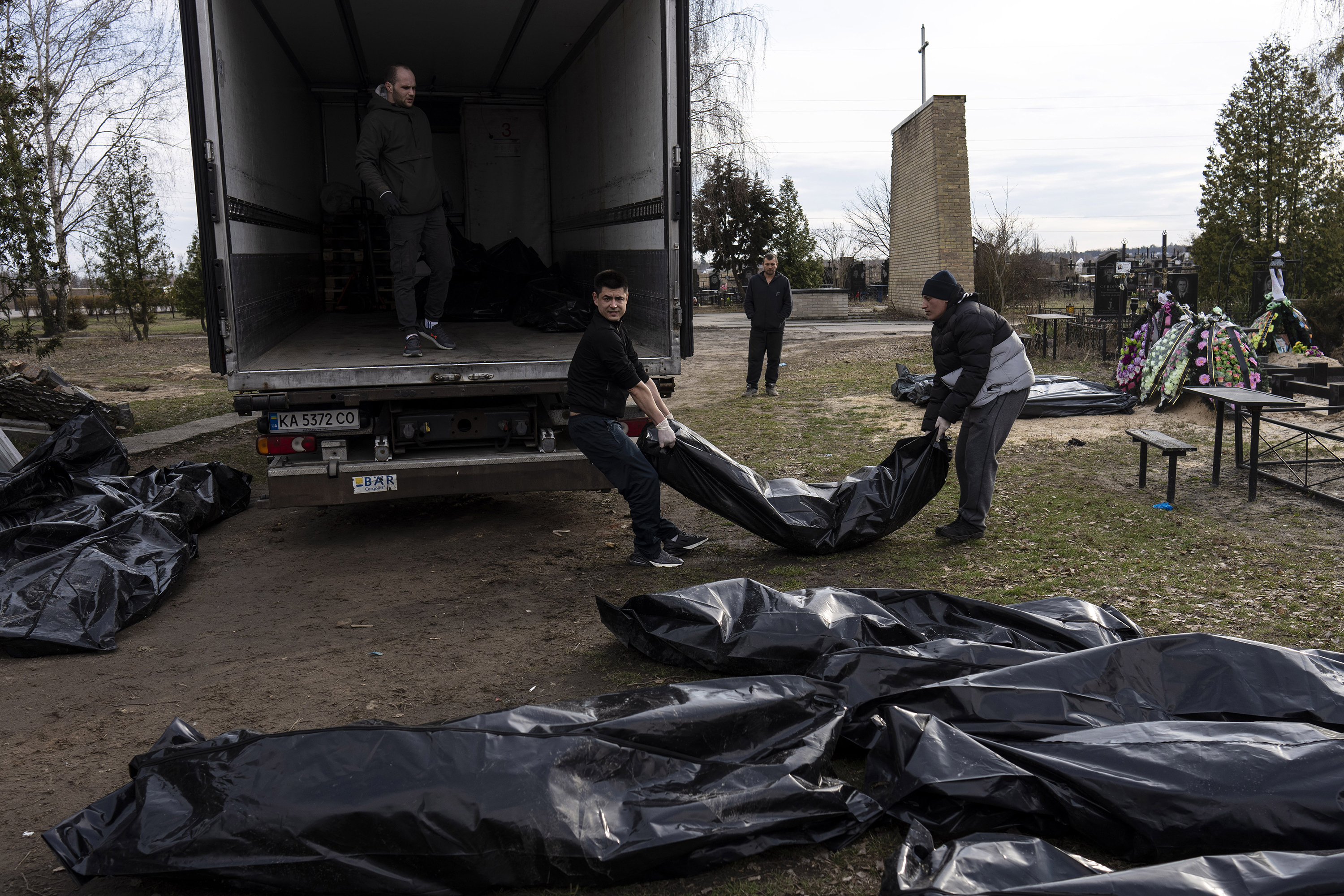 April 6: Cemetery workers load the corpses of civilians killed in Bucha, on the outskirts of Kyiv, to be transported to the morgue.
