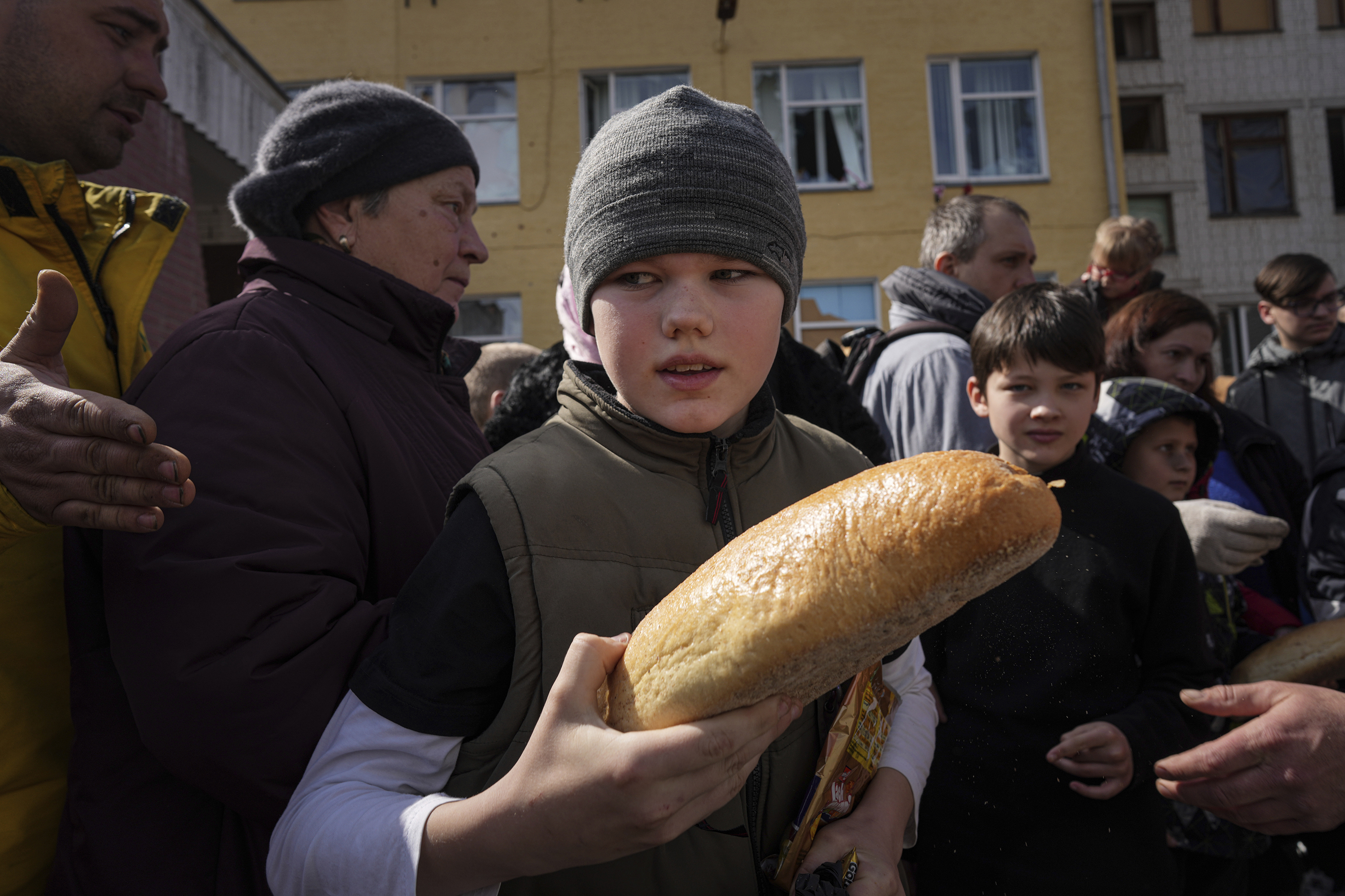 April 7: A boy holds a loaf of bread he received as part of humanitarian aid being handed out in front of a school in Chernihiv, in northern Ukraine.