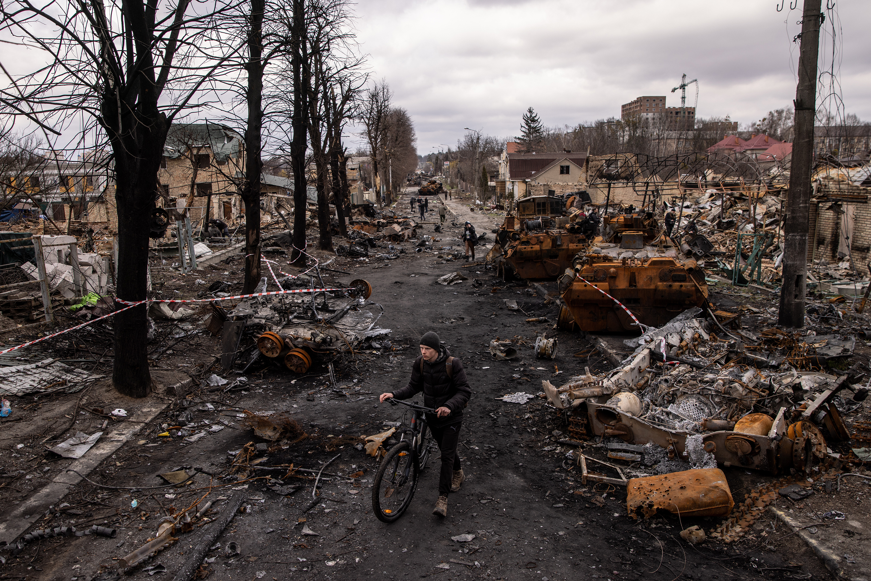 April 6: A man pushes his bike through debris and destroyed Russian military vehicles on a street in Bucha, where the Ukrainian government has accused Russian forces of committing a "deliberate massacre."