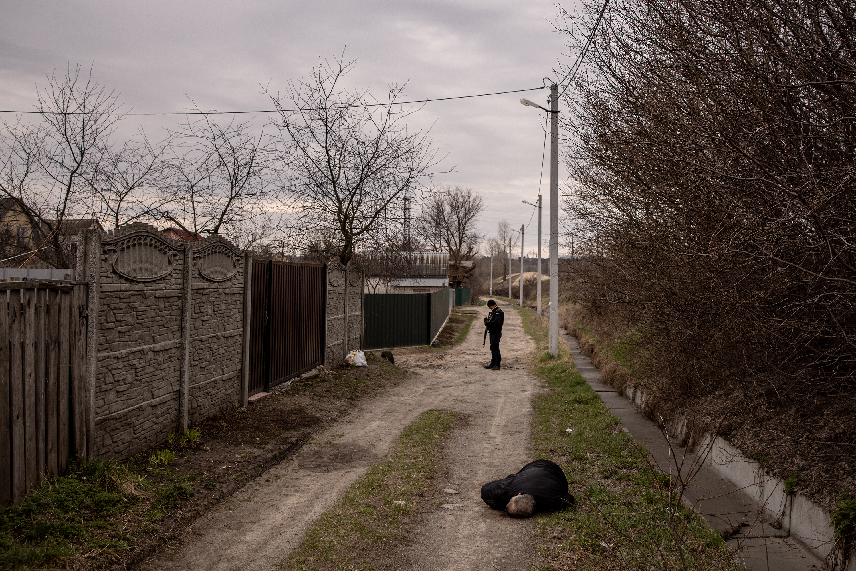 April 6: A police officer stands behind the body of a civilian allegedly shot by Russian forces on a road in Bucha, on the outskirts of Kyiv.