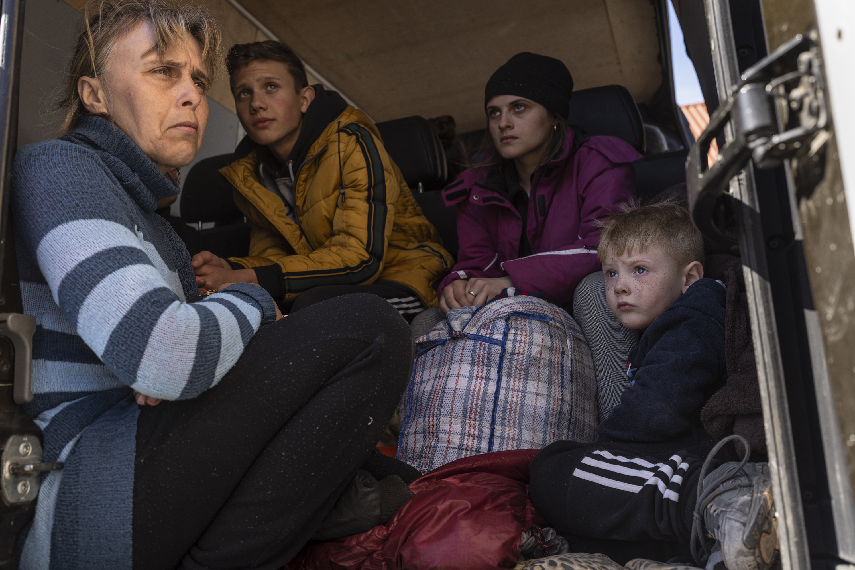 April 7: Oksana Gavrielutca, 41, (from left) sits at the back of a bus with her children Oleg, 18, Diana, 17, and Vlad, 5, after they fled from the village of Snigiriovka, in southern Ukraine.