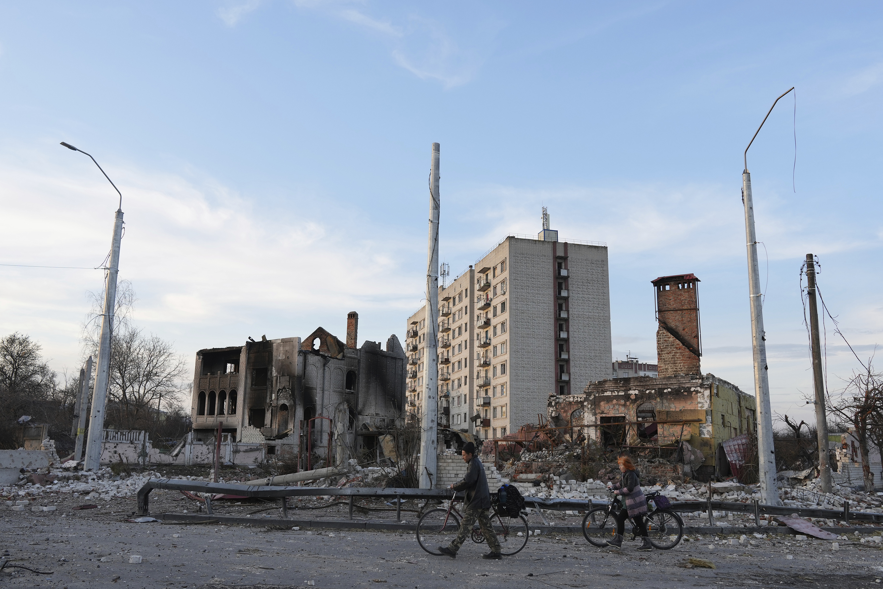 April 7: People walk bicycles past apartment buildings destroyed by shelling in Chernihiv, in northern Ukraine.