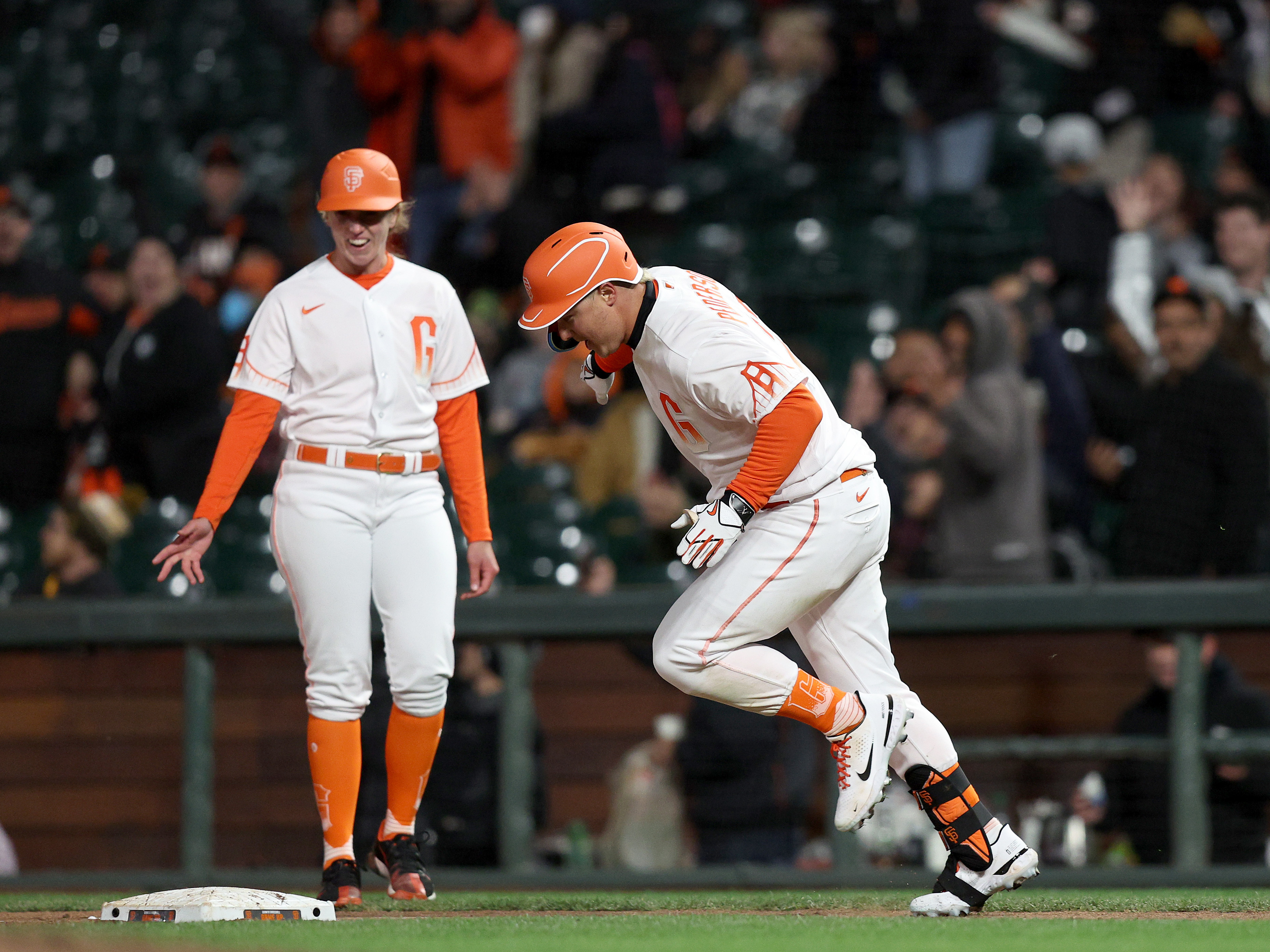 Alyssa Nakken of the San Francisco Giants, left, became the first female on-field coach in league history during a game against the San Diego Padres at Oracle Park on Tuesday in San Francisco. (Getty Images)