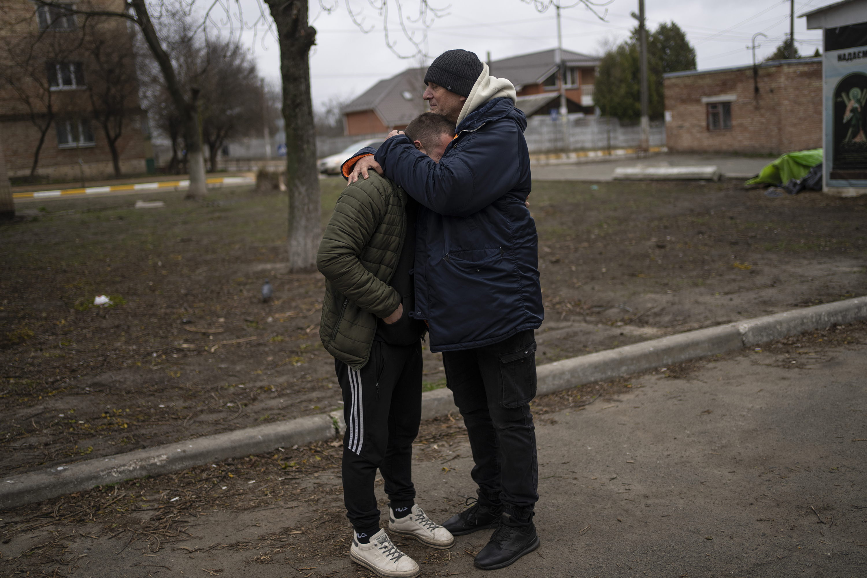April 13: The father (right) and a friend (left) of Anatoliy Kolesnikov, 30, who was killed by Russian soldiers while trying to evacuate from Irpin, a suburb of Kyiv, Ukraine, embrace outside the morgue in nearby Bucha.