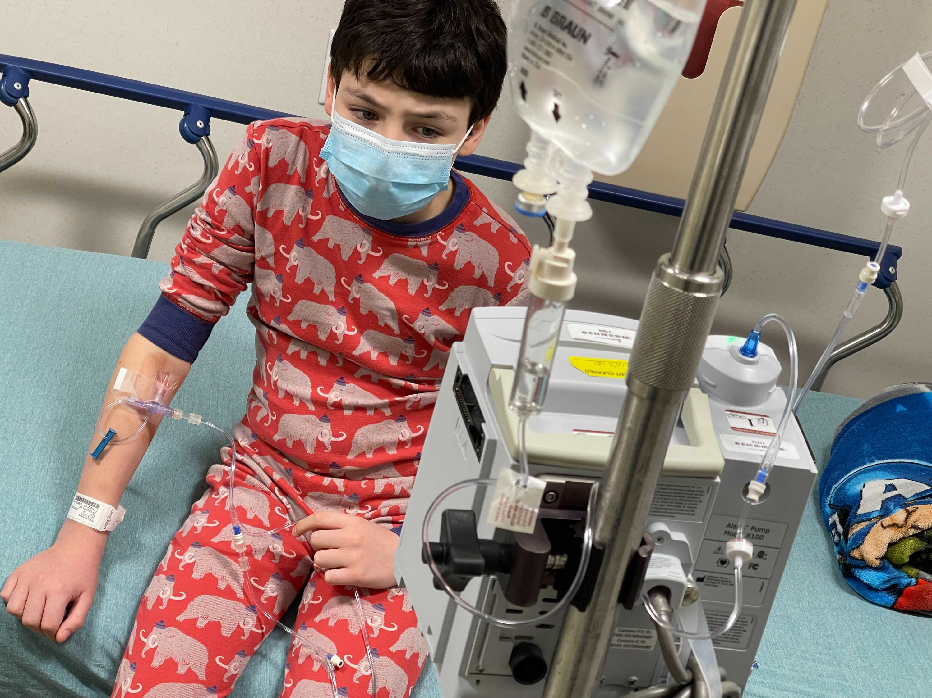 A case of COVID-19 brought 12-year-old Harry Nelson to the emergency room in Syracuse, N.Y., where cases are surging, His mother, photographer Paula Nelson, says he first had mild symptoms — just a headache — but later ran a high fever and began vomiting, which meant he couldn't keep down fever-relief meds. At the ER, he needed saline to rehydrate, Tylenol for his fever and meds to stop vomiting. (Paula Nelson for NPR)