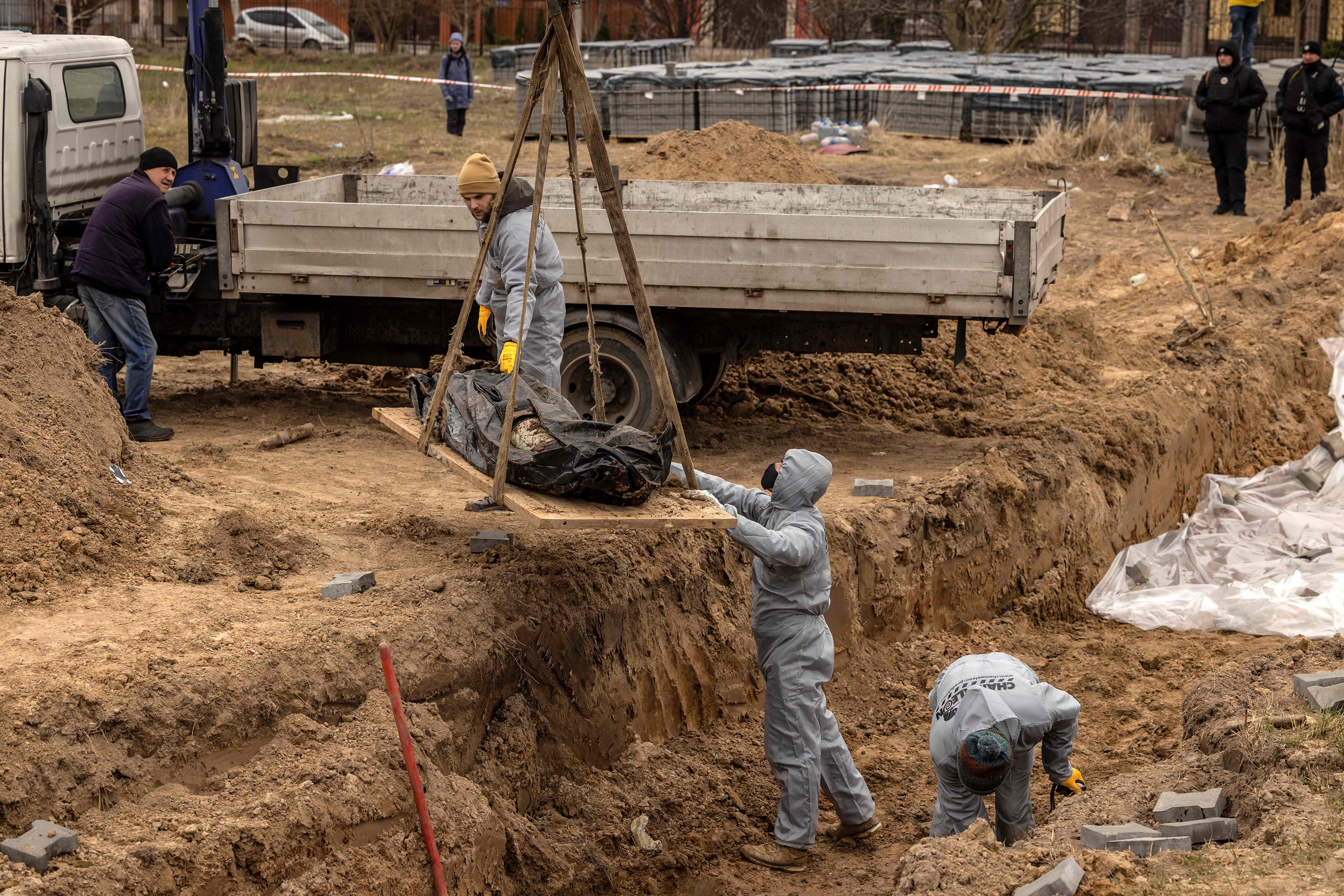 April 13: Workers wearing protective gear exhume bodies on the grounds of the Church of Saint Andrew, where civilians were buried during Russia's occupation of Bucha, on the outskirts of Kyiv.