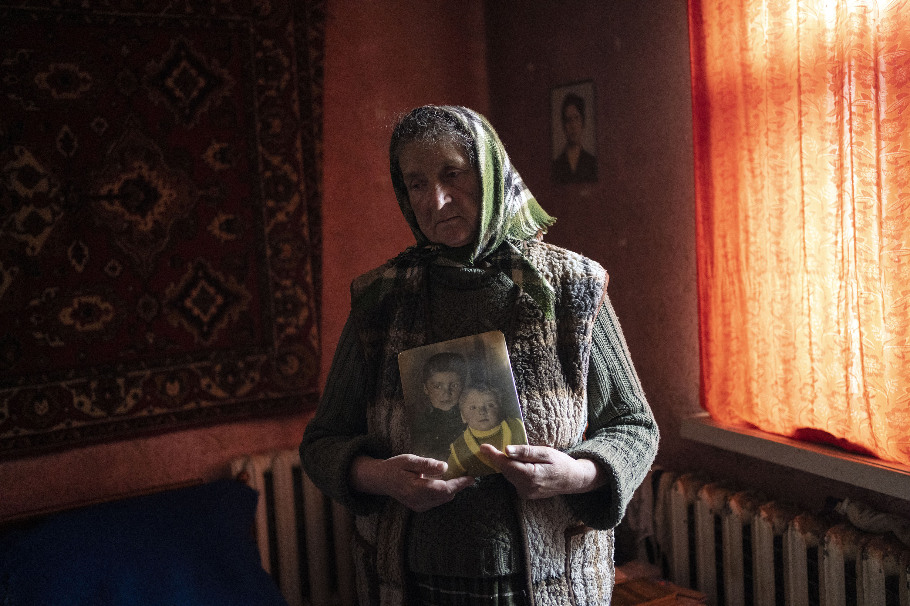 April 14: Nadiya Trubchaninova, 70, stands in her bedroom holding a portrait of her sons Oleg Trubchaninov, 46, and Vadym, 48, who was killed by Russian soldiers last March 30 in Bucha, in the outskirts of Kyiv, Ukraine.